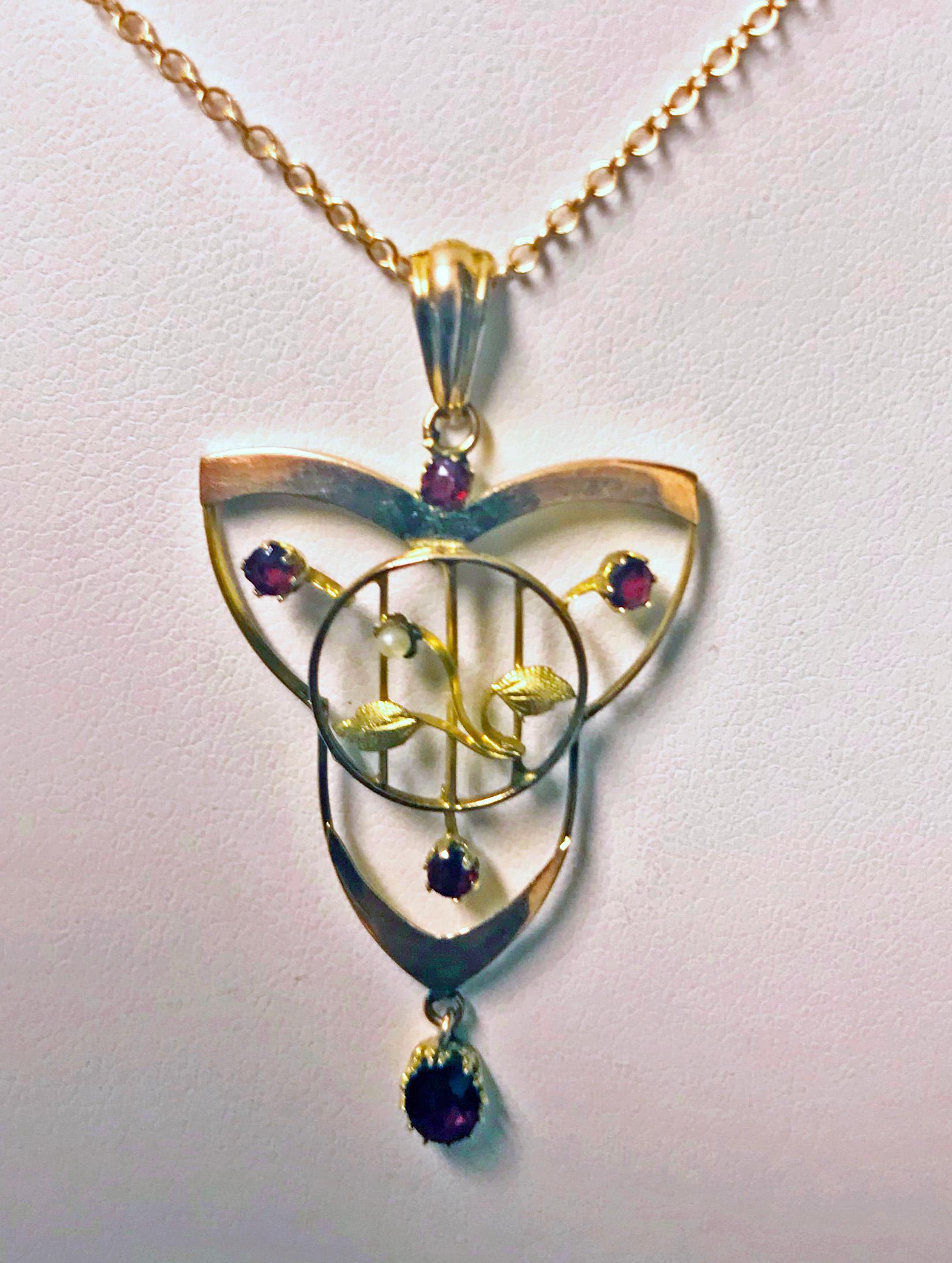 Art Nouveau Jugendstil Gold Pendant, C.1900. The Pendant 14K rose gold accented with five garnets and small seed pearl (replacement) with two green gold floral branch leaves. Together with rose gold chain, stamped 14K and 583. Length: 18.5 inches.