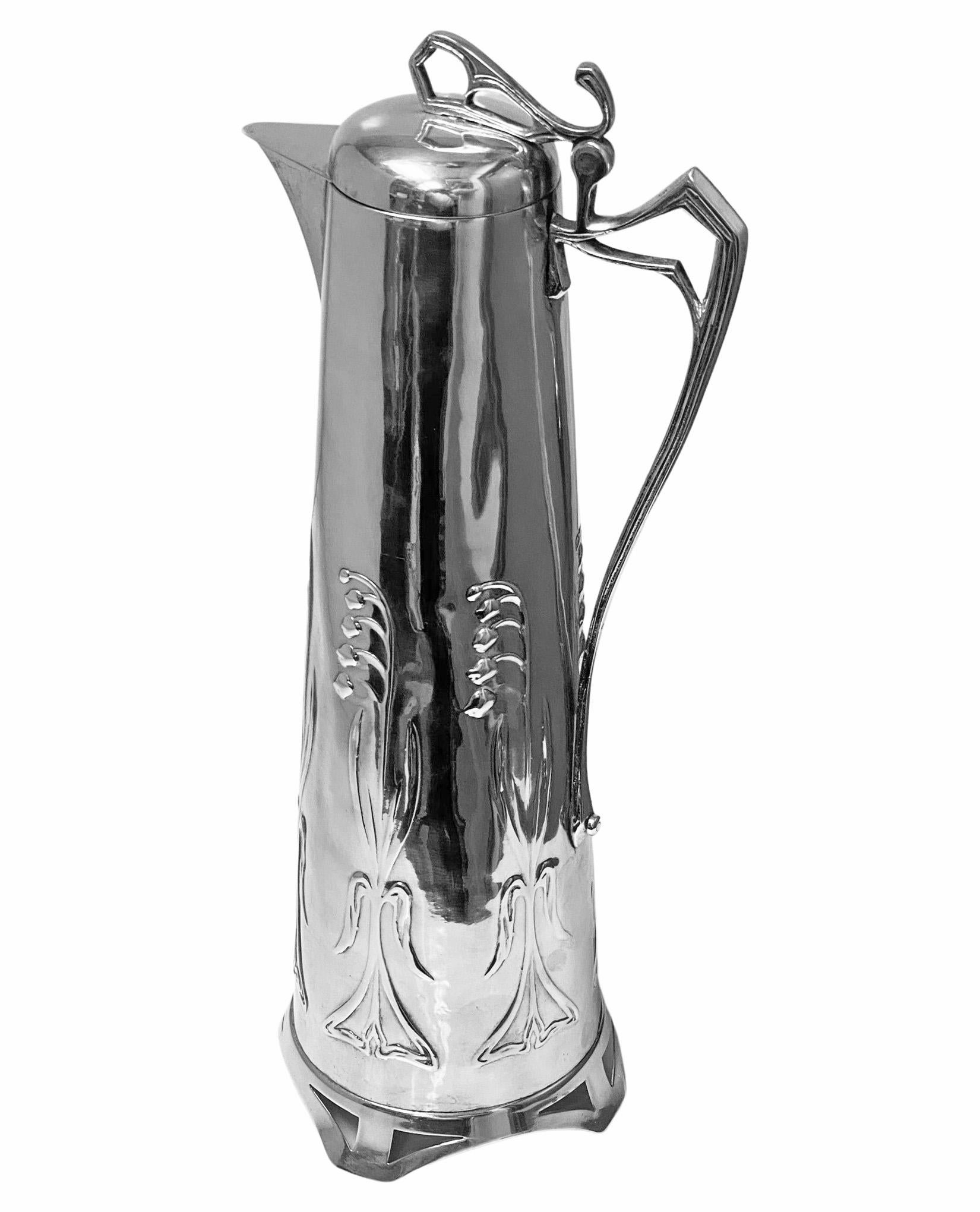 Art Nouveau Jugendstil Pewter wine or water pitcher, C.1900, probably Austrian. Art Nouveau lily of the valley decoration, slightly tapered on four bracket like conjoined supports base, stylized handle with hinged cover conforming in design. Stamped