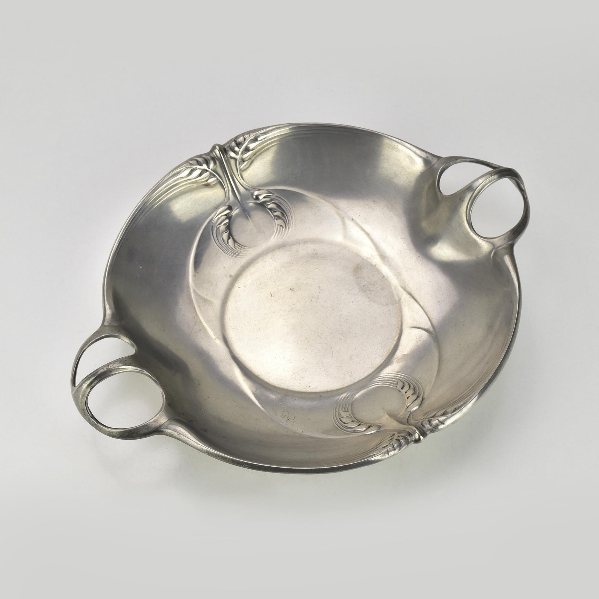 This exquisite Art Nouveau pewter bowl by Kayserzinn, designed by Hugo Leven, showcases the fluid, organic aesthetics of the Jugendstil movement. Crafted circa early 20th century, the bowl features elegant stylized wheat motifs in relief,