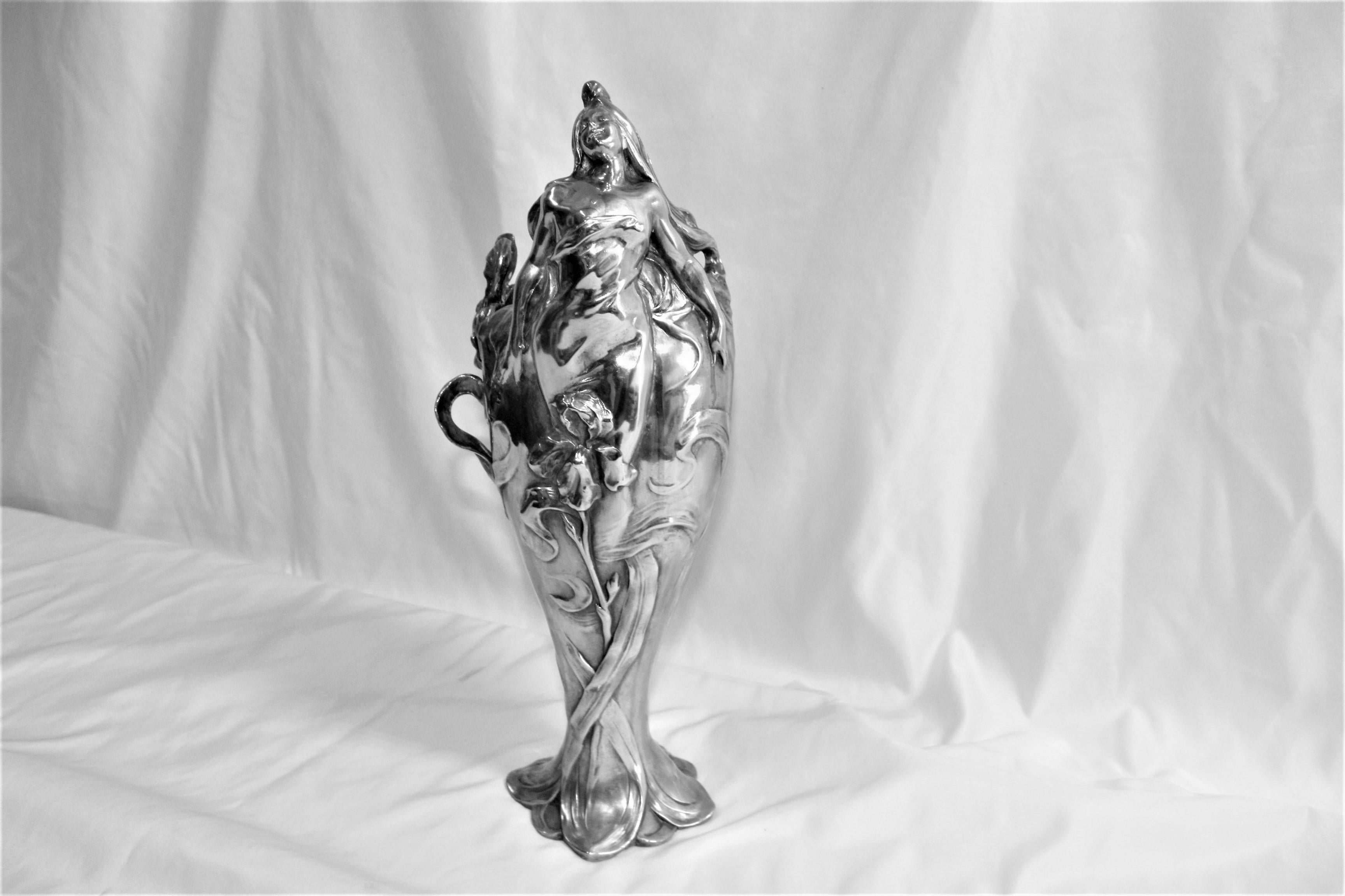 A beautiful young girl on top of the vase with her arms outstretched above an Orchid on the side. All hand finished and hi-polished in Nickel or Chrome. Signature is hard to read (Bo Nefond ) and foundry stamp on the bottom. From a private