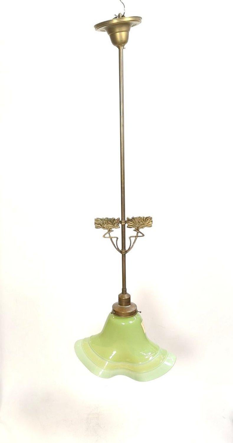 Art Nouveau copper pendant with a green glass shade by Márton Horváth, from the 1910s. Long copper stem with art nouveau stylized flower ornaments on the lower half. In excellent condition.