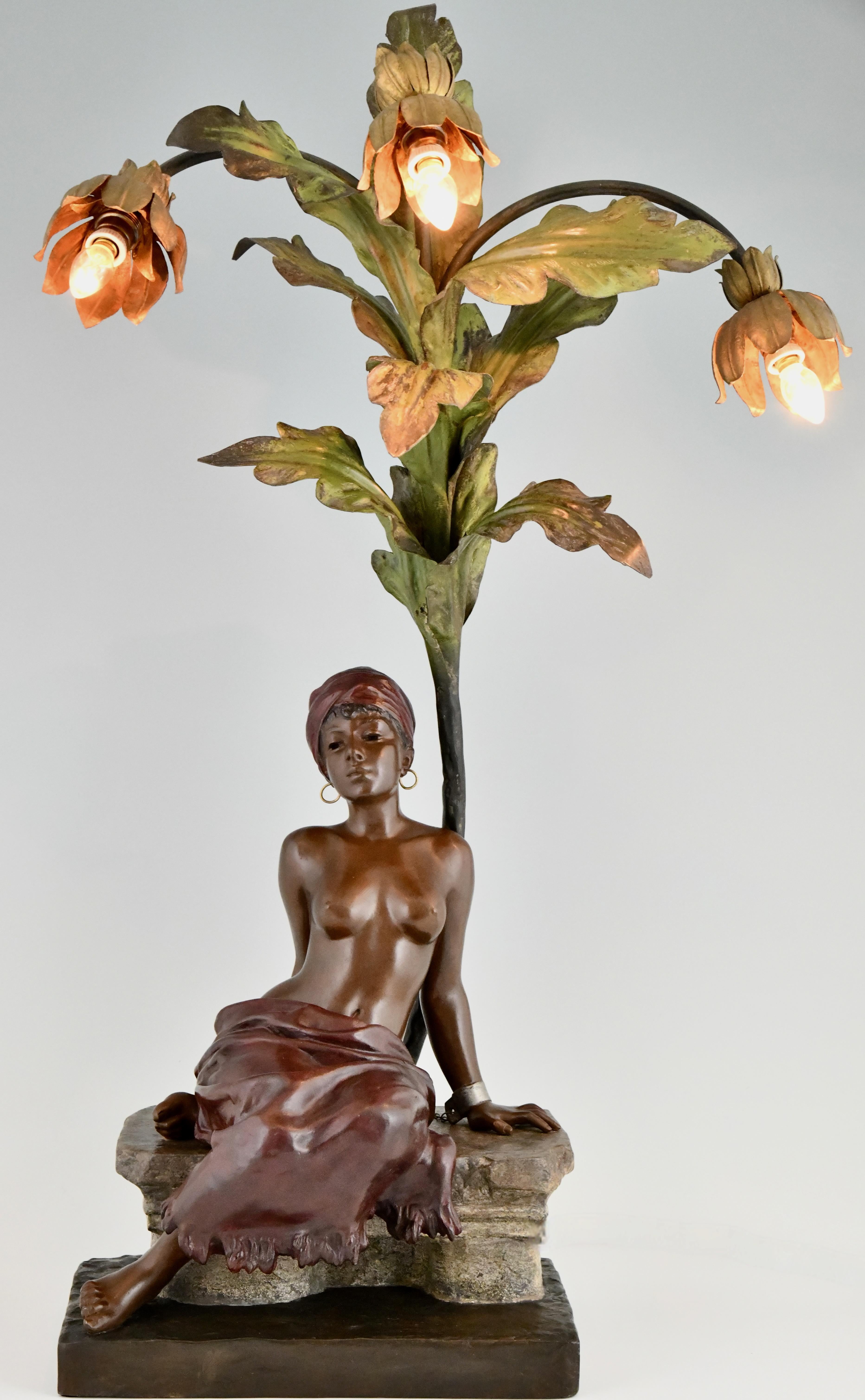 Art Nouveau lamp slave girl under palm tree by Emmanuel Villanis, removable skirt, erotic. 
Art metal, cold painted patina. France 1900. 
H. 82 cm. 
A slave girl sitting under a palm tree, her hands chained behind her back. 
She is wearing earrings,