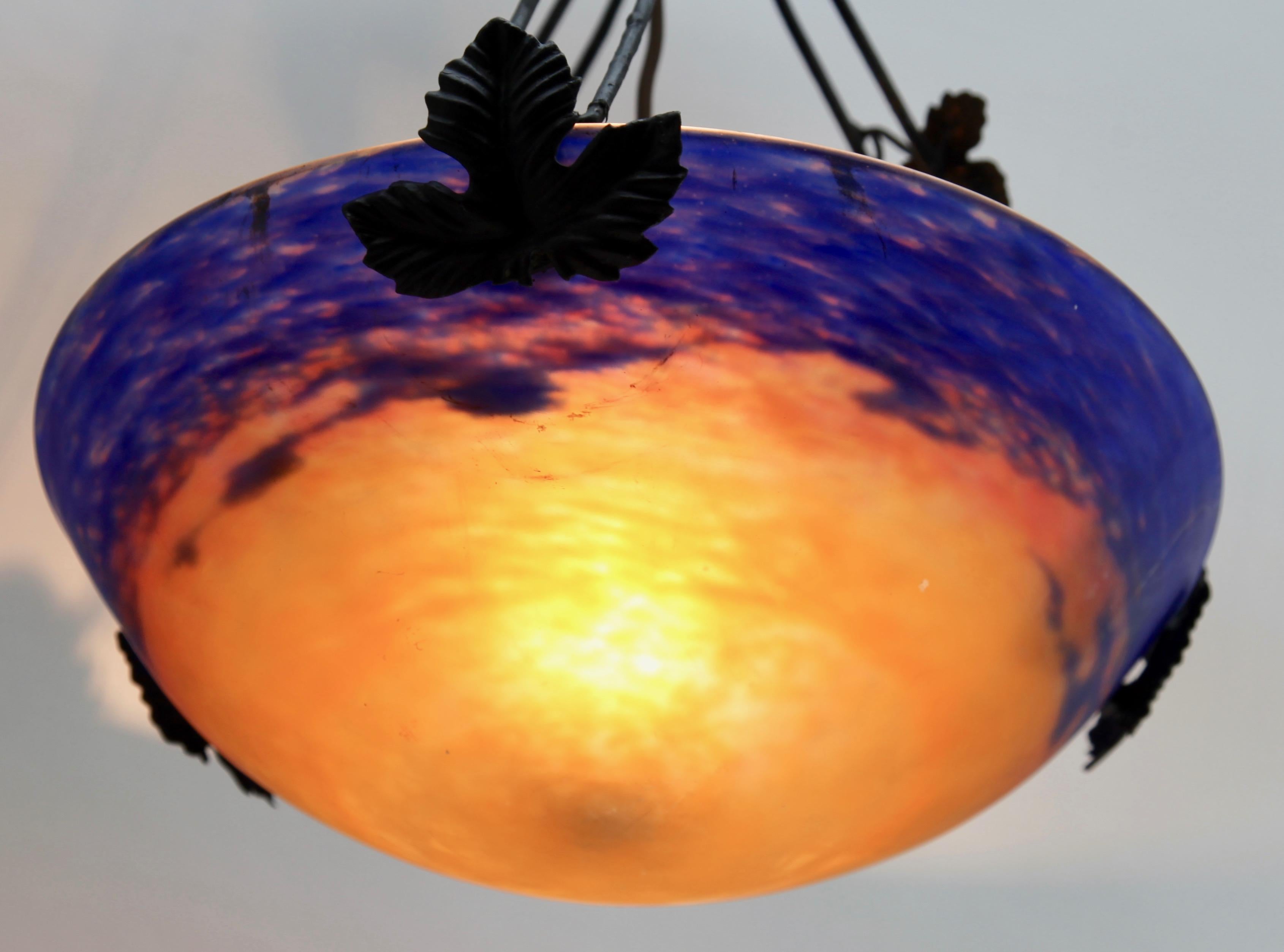 Art Nouveau style lampshade, fully signed, by Muller Freres, Luneville, circa 1925
Mottled glass shade with 'Sunset' decor of orange surrounded by cloudy blue. Colored powders are applied between two layers to create the effect, and acid-etched