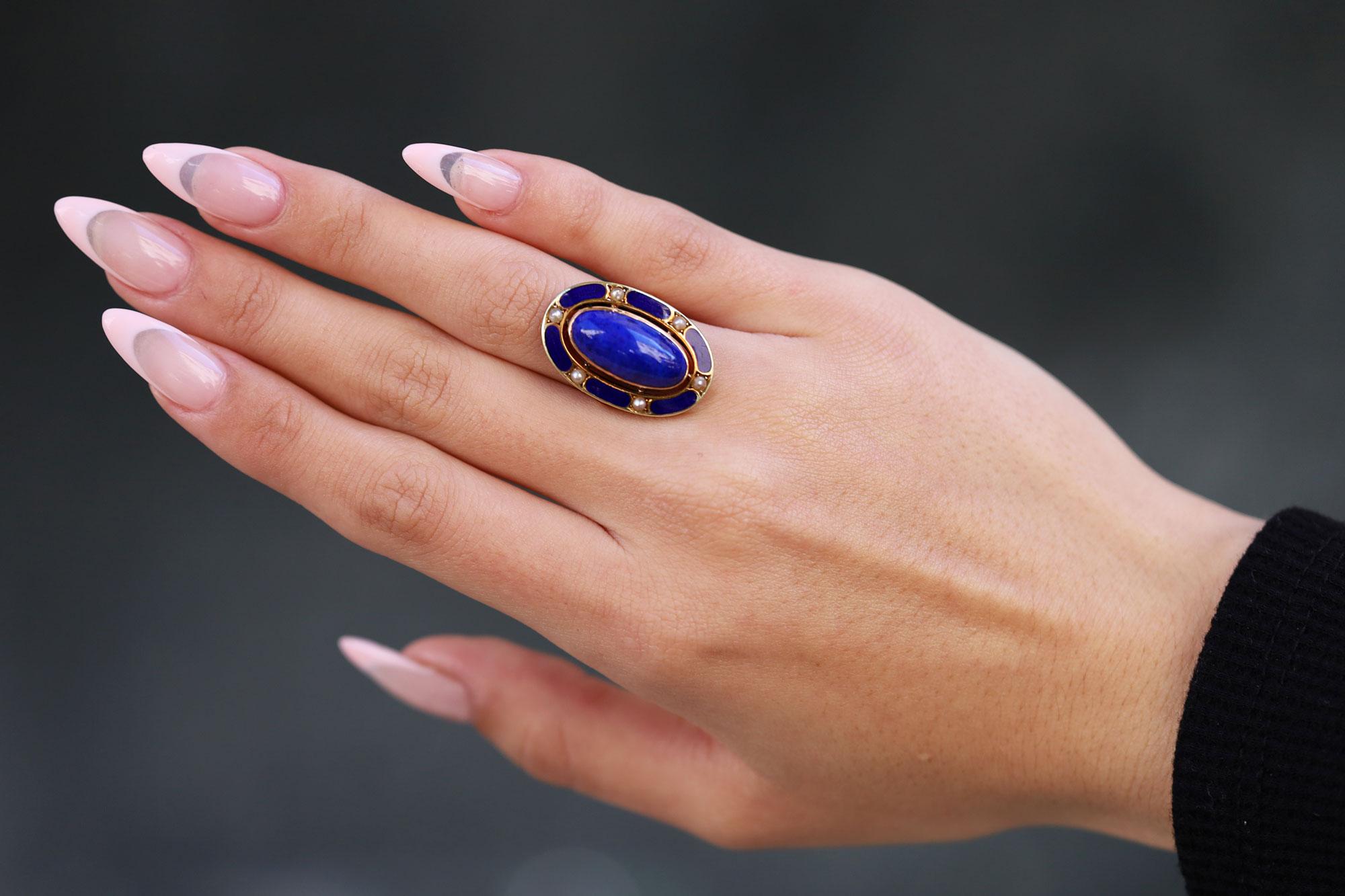 A rich, velvety blue lapis lazuli and enamel cocktail ring providing outstanding finger coverage and a unique silhouette, dating from the Art Nouveau/Art Deco era. Creating a harmonious symphony composed as an elongated ellipse, offset with a