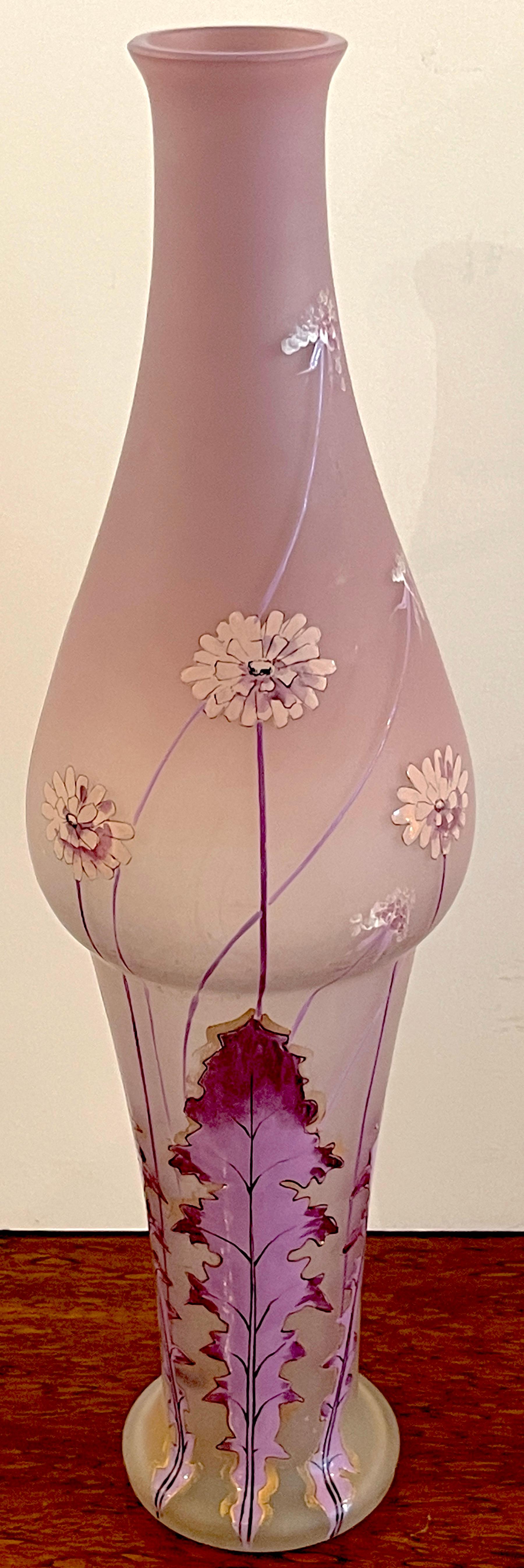 Art Nouveau Lavender Dandelion (Taraxacum) Enameled Vase, 
Attributed to the Mont Joye Glassworks 
France, Circa 1900s
A unique work with the elongated neck and bulbous body resting on a tapering pedestal base.Realistically enameled with flowing
