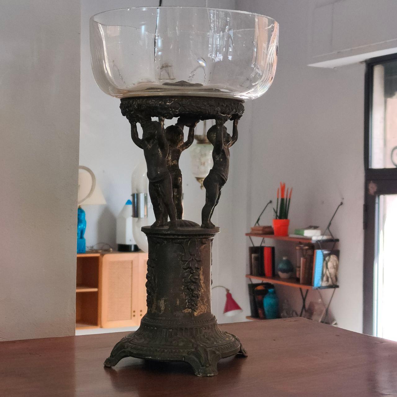 Soporte para tartas de estilo Art Nouveau, fabricado en Italia en la década de 1920, hecho de fundición de antimonio con un cuenco superior de cristal. La base, maciza y ligeramente bruñida por la pátina del tiempo, está decorada con elegantes