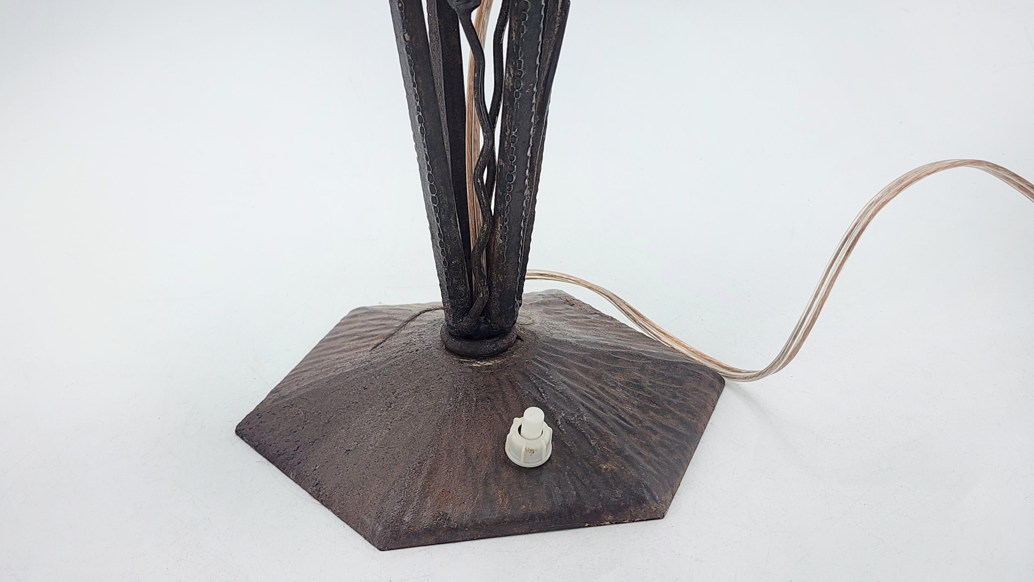 Lampe de table art déco avec capuchon en verre dépoli
Cette lampe de table Art déco présente une base en métal foncé avec un design organique de supports incurvés convergeant vers une base polygonale. L'abat-jour en verre dépoli a une forme
