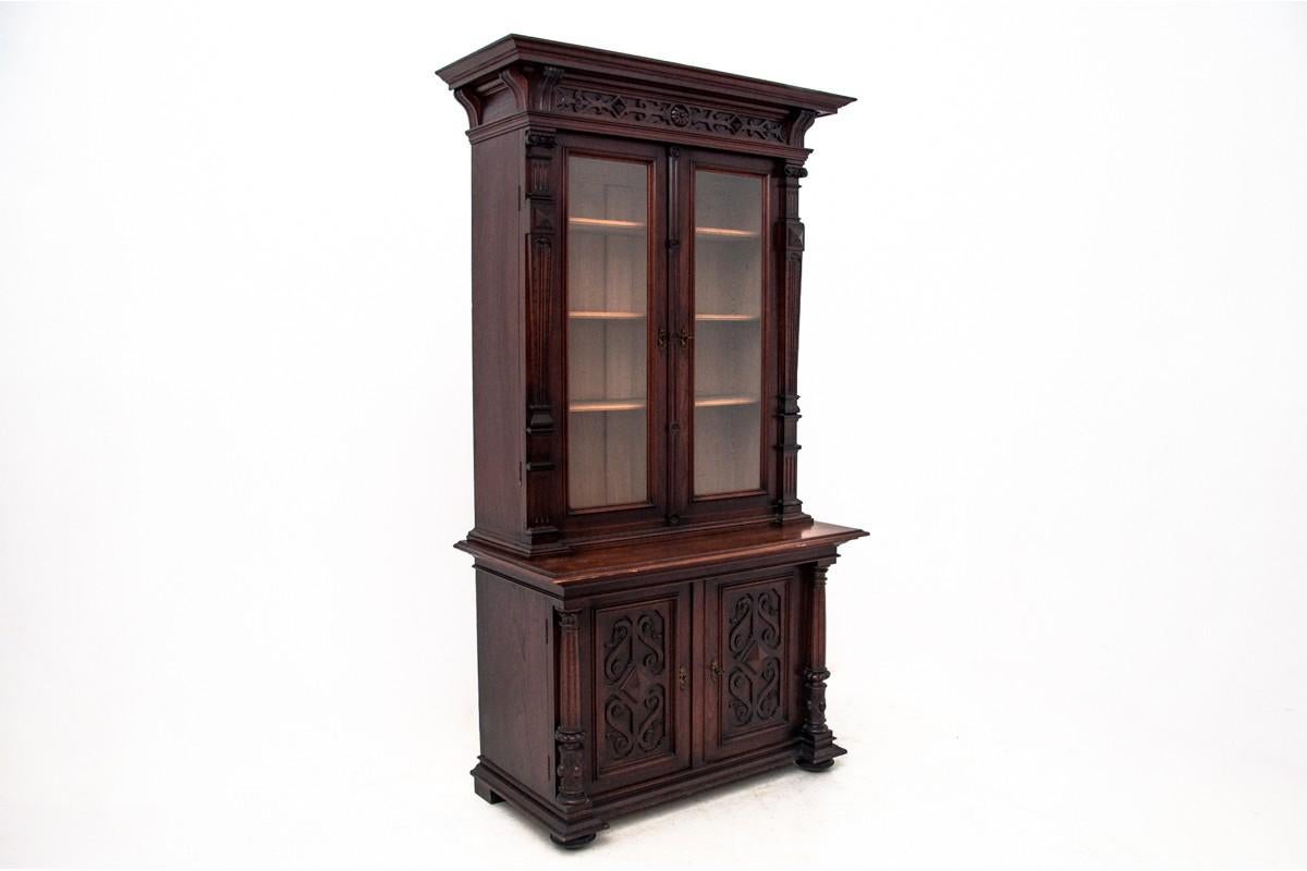 Antique bookcase or vitrine from circa 1920. Made of oakwood.

The upper part consists of a glazed display case with shelves and the lower part of a capacious chest of drawers with one shelf.

Dimensions: height 215 cm / width 120 cm / depth 58