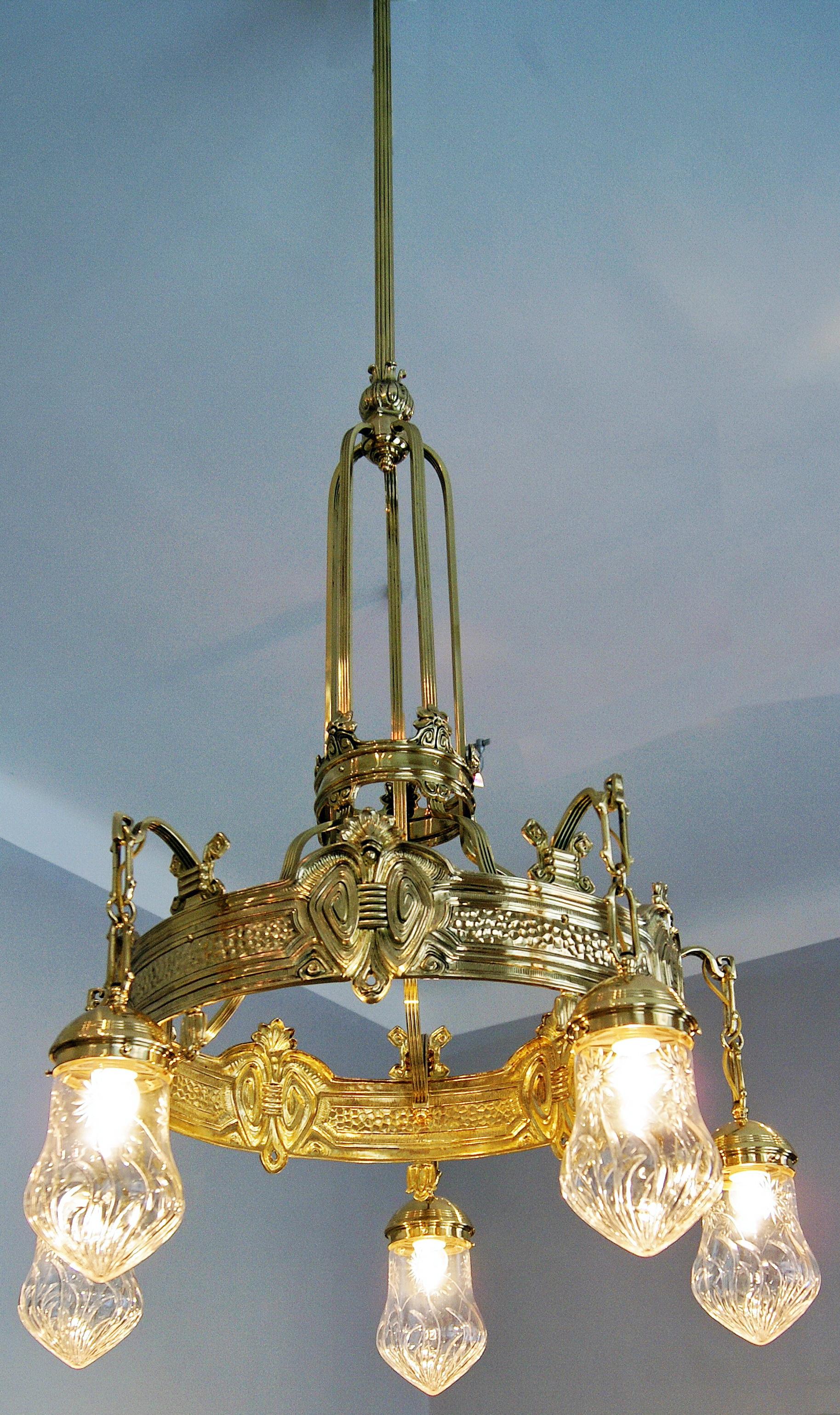 Most elegant tall art nouveau brass lustre, chandelier and candelabrum with five bulbs,
made by Viennese manufactory, circa 1910.

Specifications:
Five tapered bulbs made of glass - each of them cut with decorative patterns - are attached to