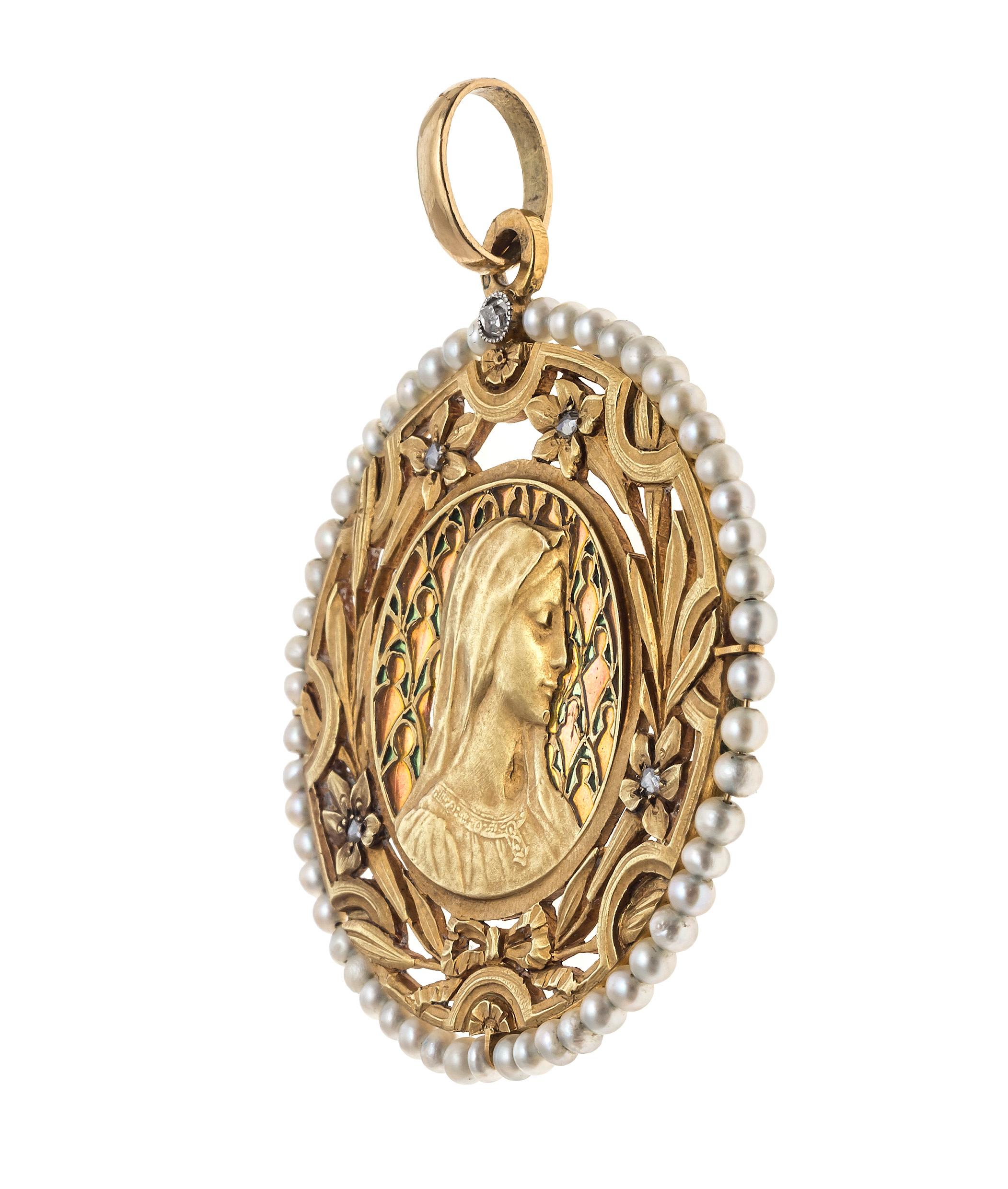 This beautiful Art Nouveau pendant shows a relief portrait of the Virgin Mary amidst a fine plique à jour enamel halo of green ornaments before an orange background. The image of Mary is surrounded by a fine cut out frame, decorated with a chiselled