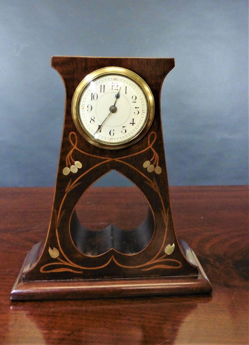 Art Nouveau Mahogany mantel clock



Small Art Nouveau mahogany mantel clock standing on a raised, moulded plinth with heart shaped void strung with satinwood line decoration and inlaid with mother of pearl.

Enamel dial with Roman numerals