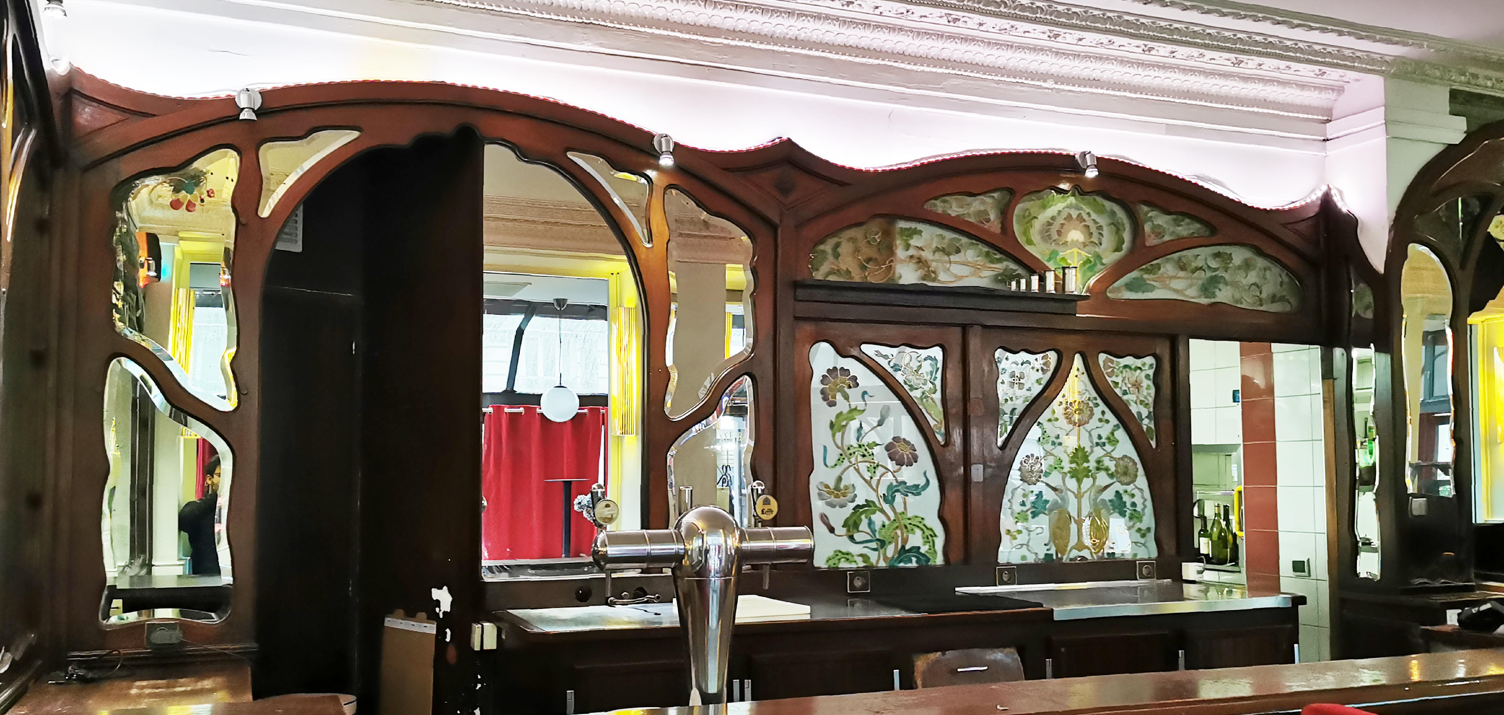 This woodwork characteristic of the Art Nouveau style comes from the Café Barjot located avenue Ledru-Rollin in the 12th district of Paris, it was made in 1905. It is composed on a first wall of a symmetrical set of seven beveled mirrors - one of