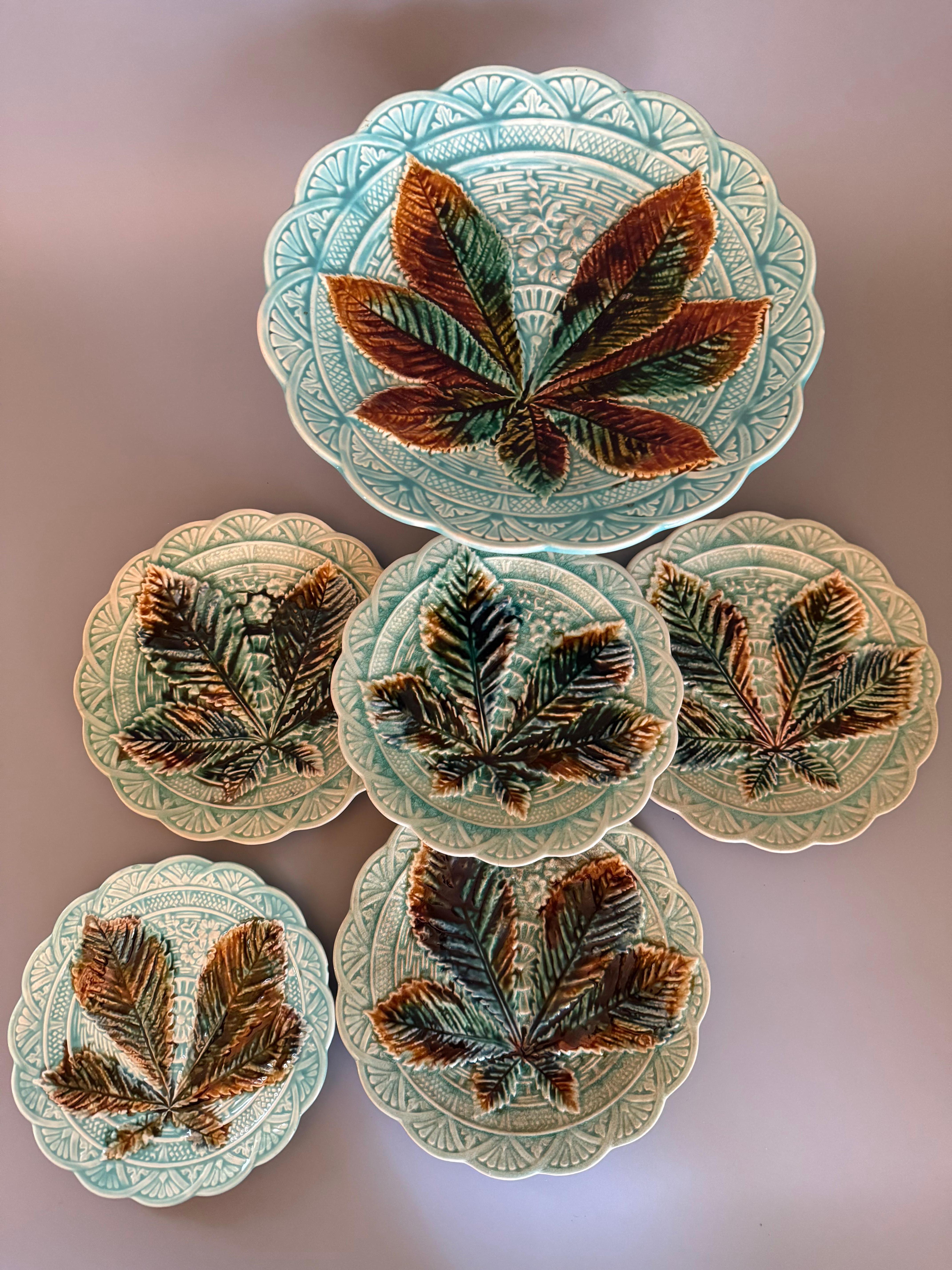 These are antique Swedish Majolica plates, likely from the 1880s, produced by the renowned Rörstrand company, one of Sweden's oldest industries. 
They feature a distinctive design with relief-molded chestnut leaves and a scalloped rim,