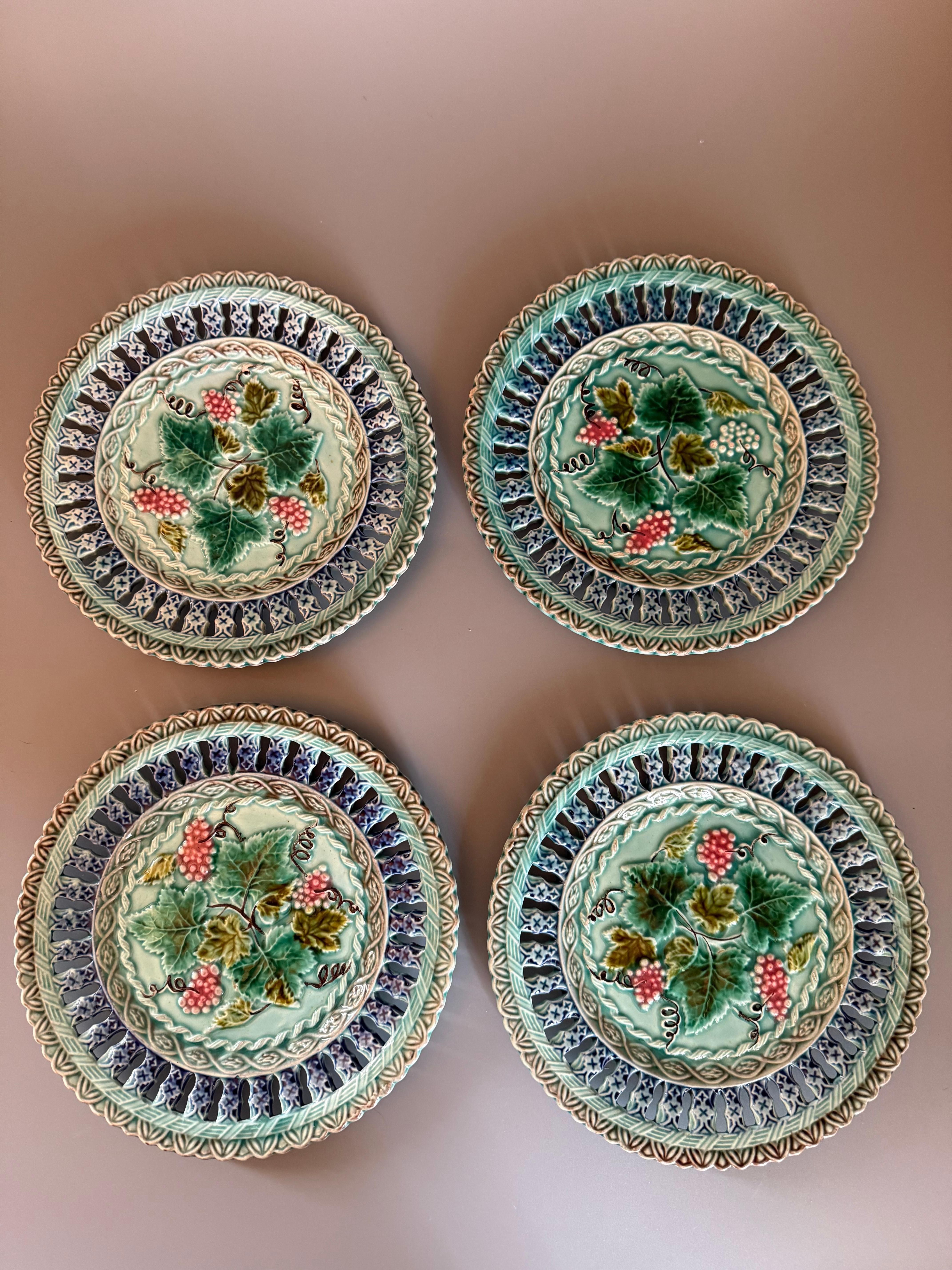 It's made of majolica, a type of tin-glazed earthenware, and exhibits characteristics of the Art Nouveau style. 
The plates have a distinctive reticulated edge and a hand-painted central motif, often featuring botanical themes like the grapes and