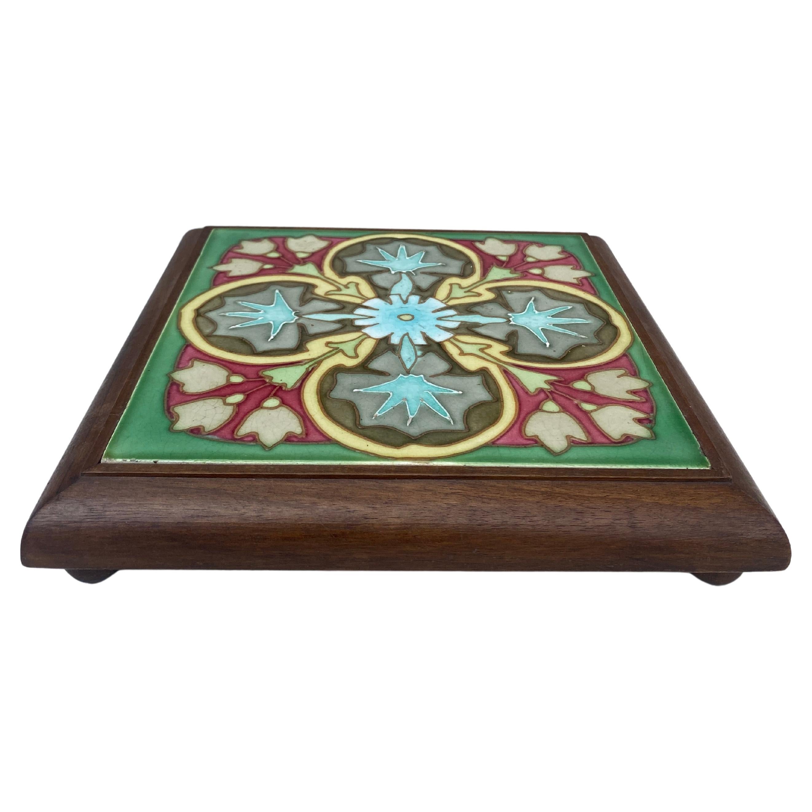 Salvamanteles de mayólica Art Nouveau en un marco de madera con patas, hacia 1900.
Motivo floral geométrico.
9,5