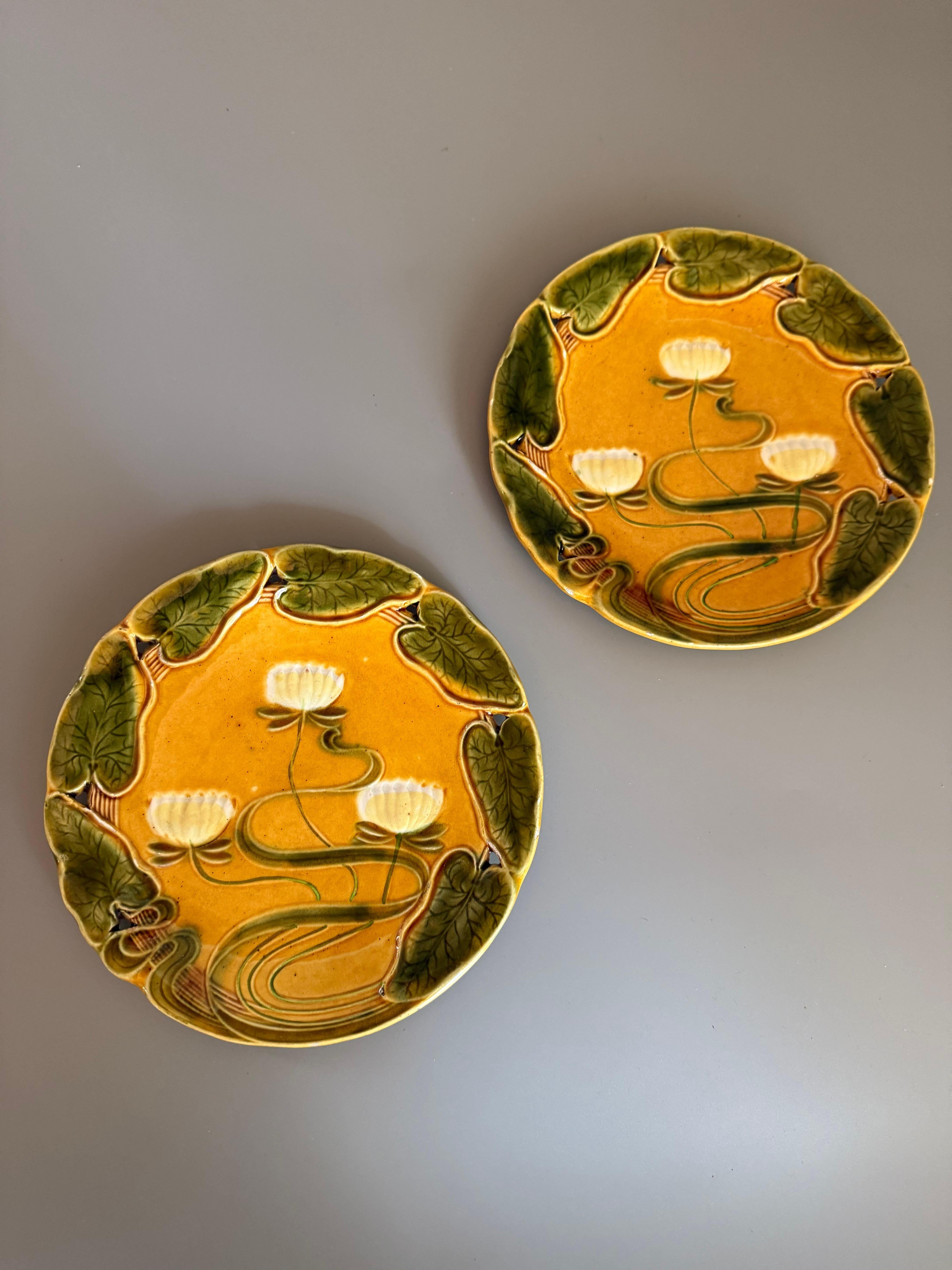 Deux assiettes anciennes Villeroy & Boch Art Nouveau Majolica Water Lily, datant probablement d'environ 1983-1912
Design :
Il présente un motif de nénuphar avec des nénuphars jaunes peints à la main sur un fond jaune vibrant, entourés de nénuphars