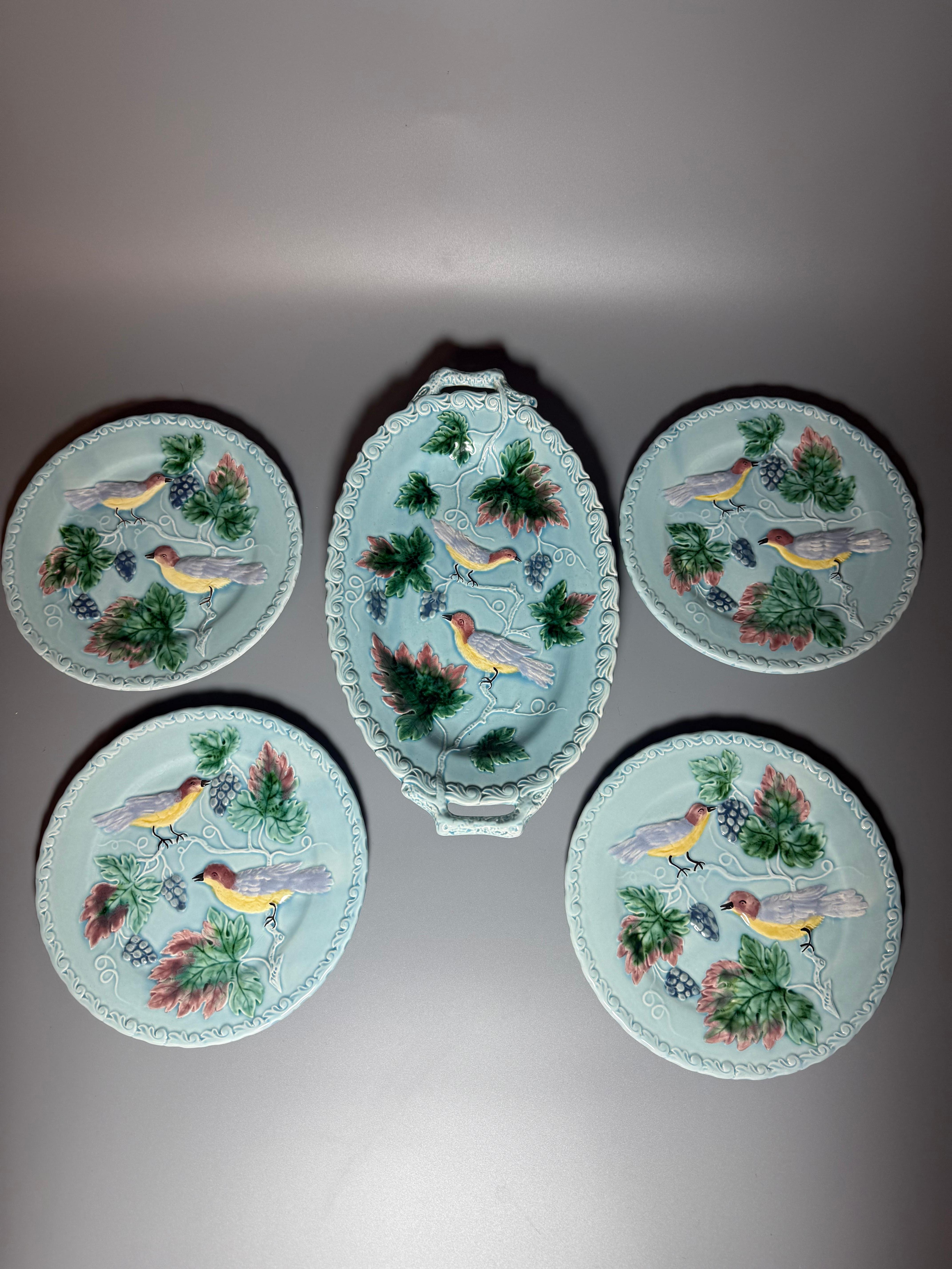 Majolica Germany 
Amazing items from Germany, middle of 20th Century 
Relief beautiful birds on floral’s motifs 
Rich colours 
Gentle turquoise base 
One serving dish length 31 cm h 4 cm
Four plates d 20 cm

All pieces are in very good vintage