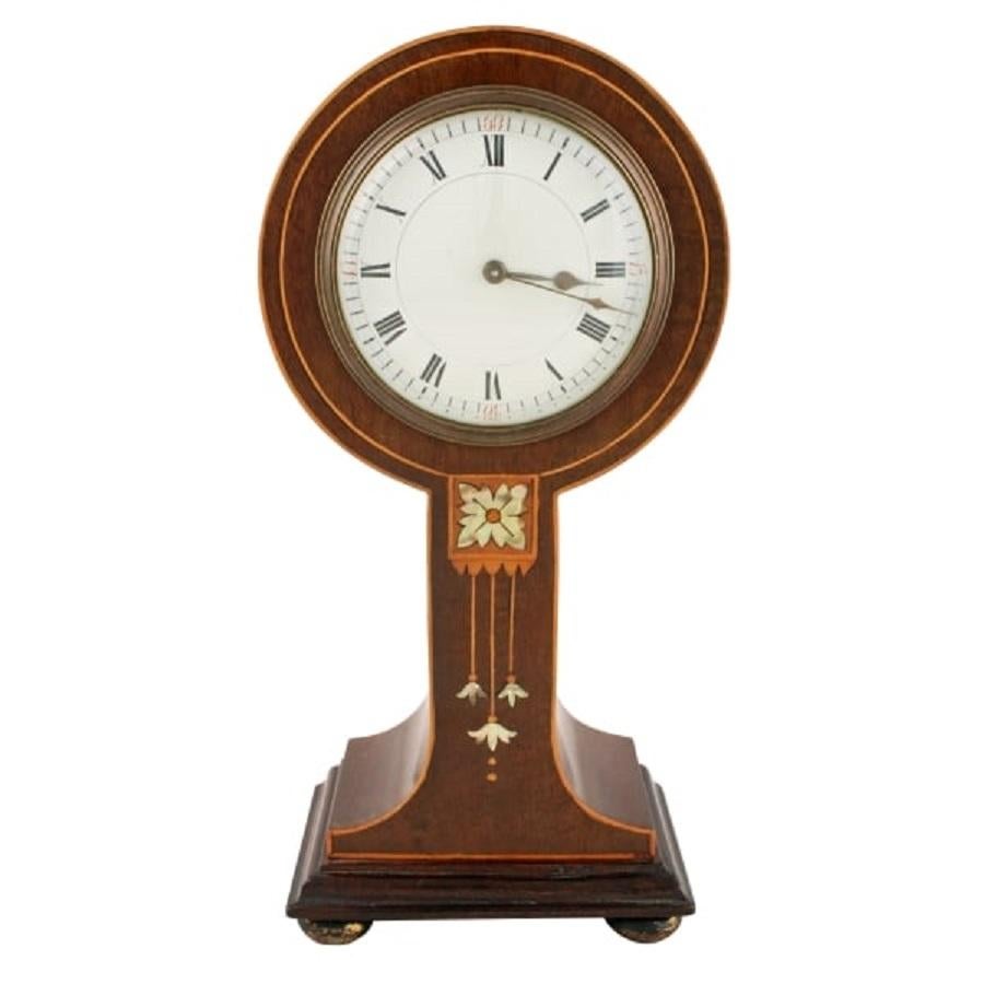 A late 19th to early 20th century Art Nouveau mahogany cased mantel clock.

The balloon shaped clock is inlaid in the style of 'Shapland & Petter Ltd' of Barnstable with boxwood, satinwood and mother of pearl inlays.

The French works are an