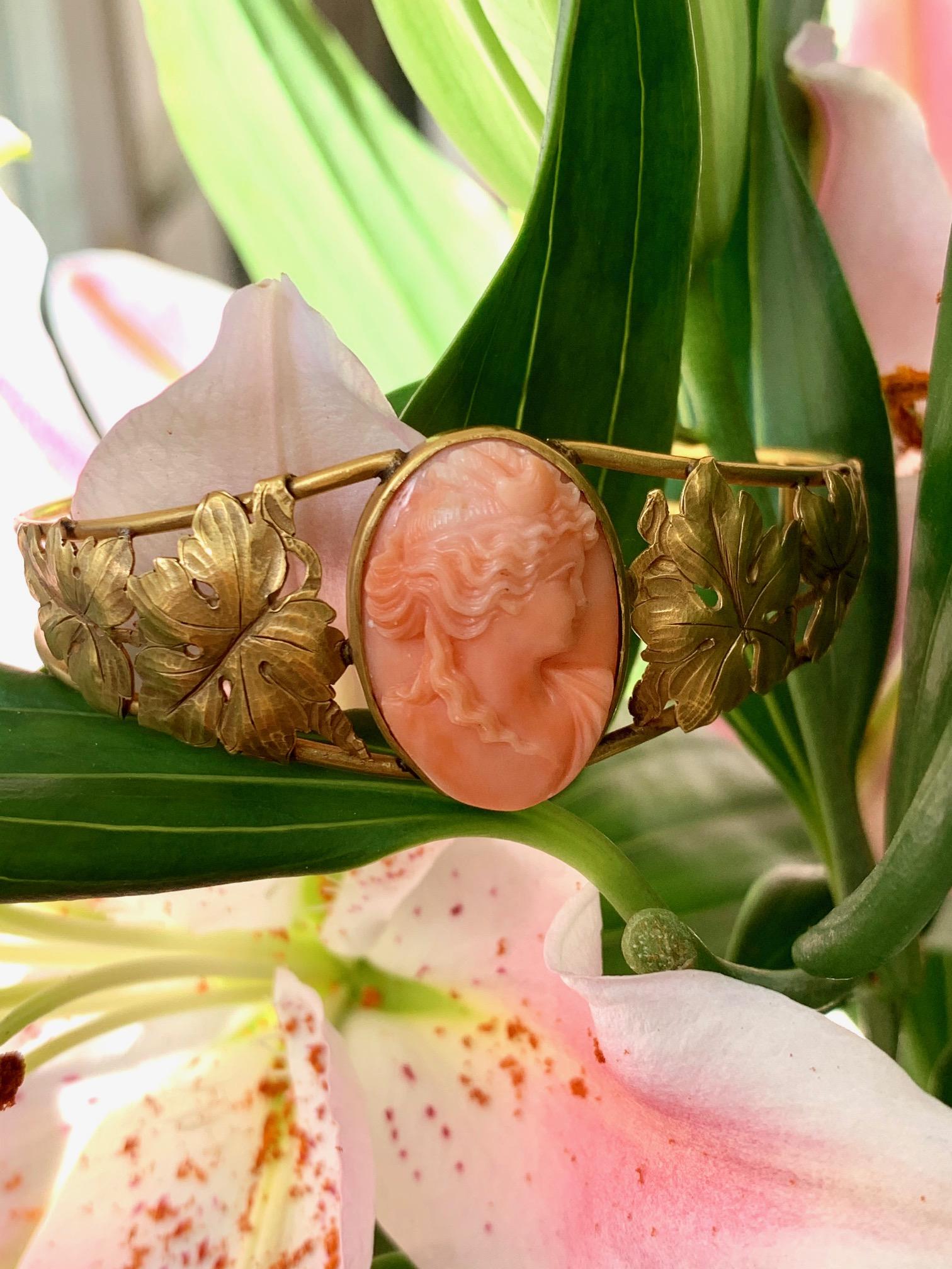This beautiful Art Nouveau 14k gold bangle with carved Mediterranean salmon coral cameo center on stylized leaf forms, is a stunner!  

The outside circumference measures 8 1/4