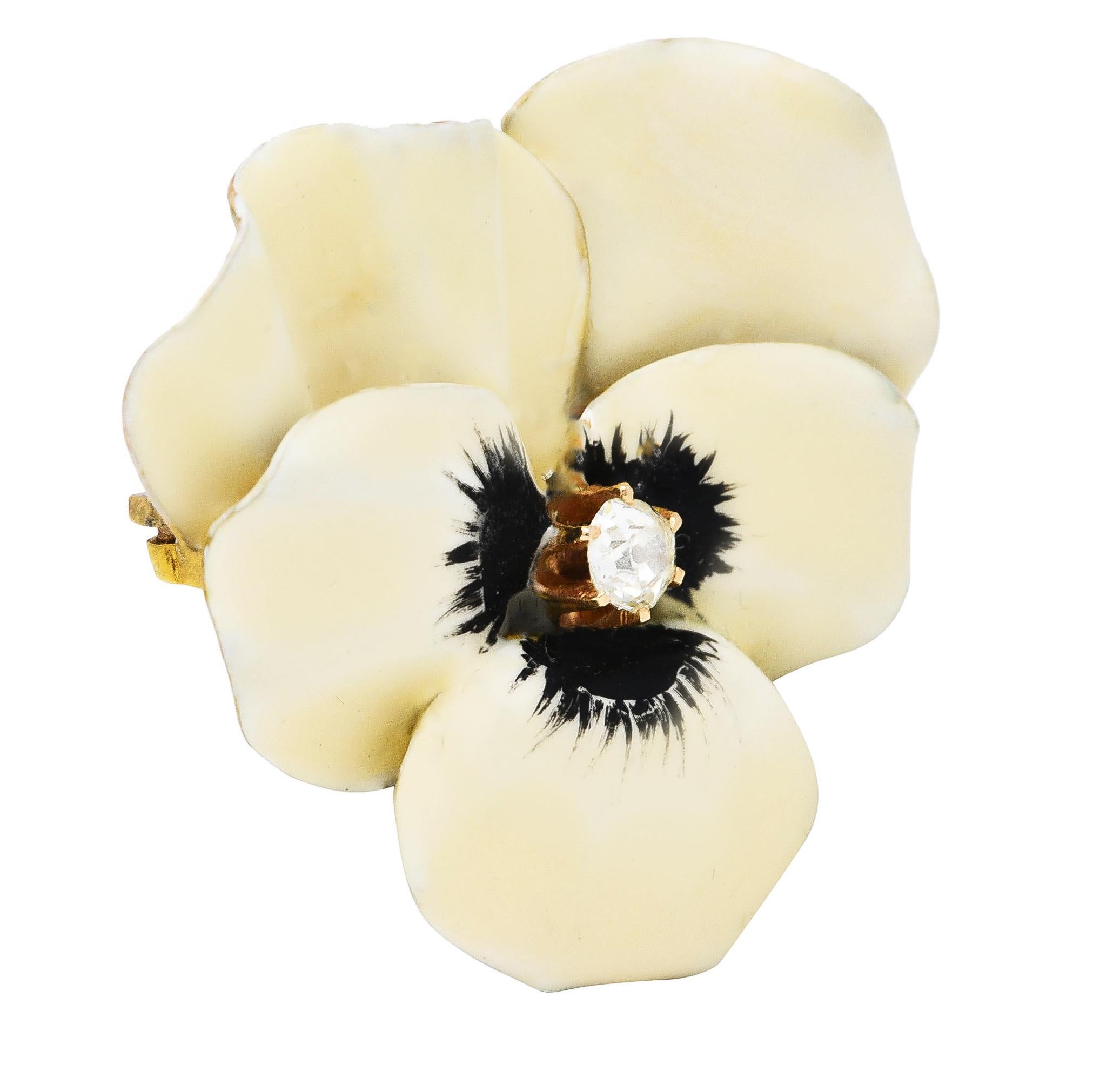 Pendant brooch is designed as a pansy flower with delicately painted matte enamel petals. Opaque cream, white, and black - minimal loss. Accented by a prong set old mine cut diamond. Weighing approximately 0.16 carat - eye clean and bright.