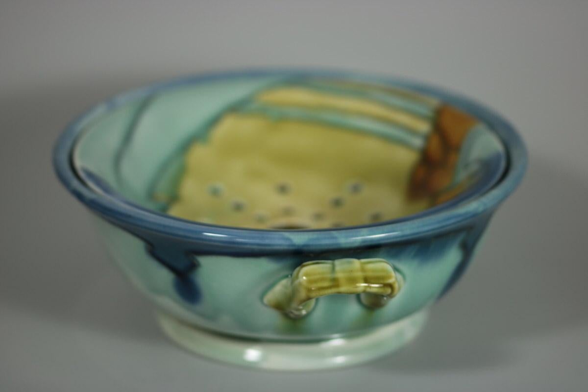 Mintons Secessionist No.8 twin handled sponge dish with removable drainer. Decorated with orange, blues and green art nouveau stylized patterns. Grey tube linings. Maker's marks including printed 'MINTONS LTD. NO. 8' and impressed date cipher for