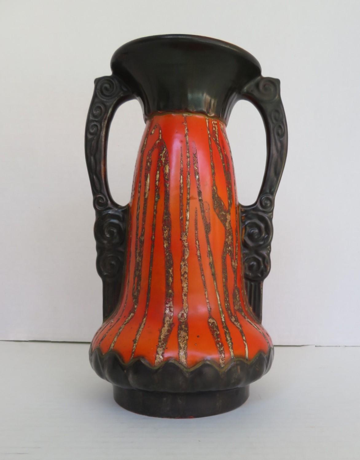 Reduced from $325....In vivid tomato red and gun metal black, a tall pre-war 1930s ceramic Art Nouveau vase with handles from former Czechoslovakia. Decorated with fluid scrolls on the handles and drips running through a red glazed body. Stamped on