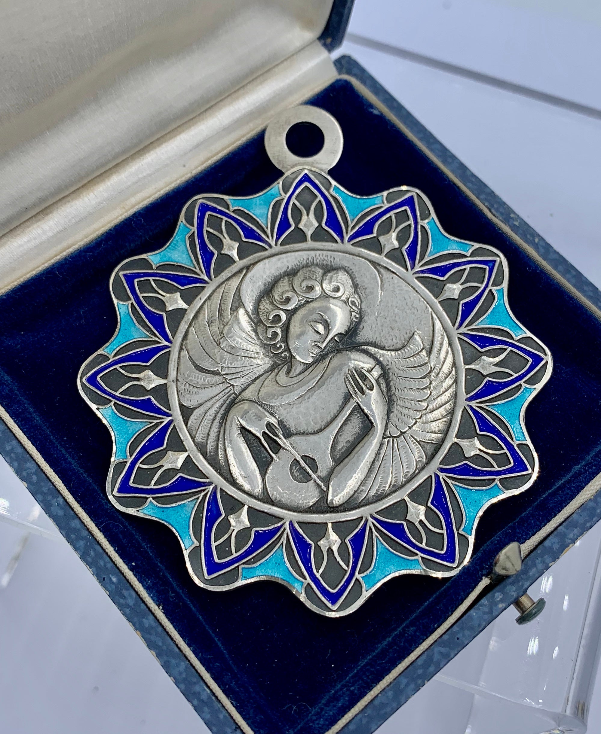 THIS IS ONE OF THE MOST BEAUTIFUL AND RARE ANTIQUE ENAMEL JEWELS WE HAVE SEEN.  THE ART NOUVEAU, MODERNIST PENDANT HAS AN EXQUISITE IMAGE OF AN ANGEL PLAYING A MUSICAL STRINGED INSTRUMENT.  THE DESIGN OF THE ANGEL IS AN EXTRAORDINARY MODERNIST