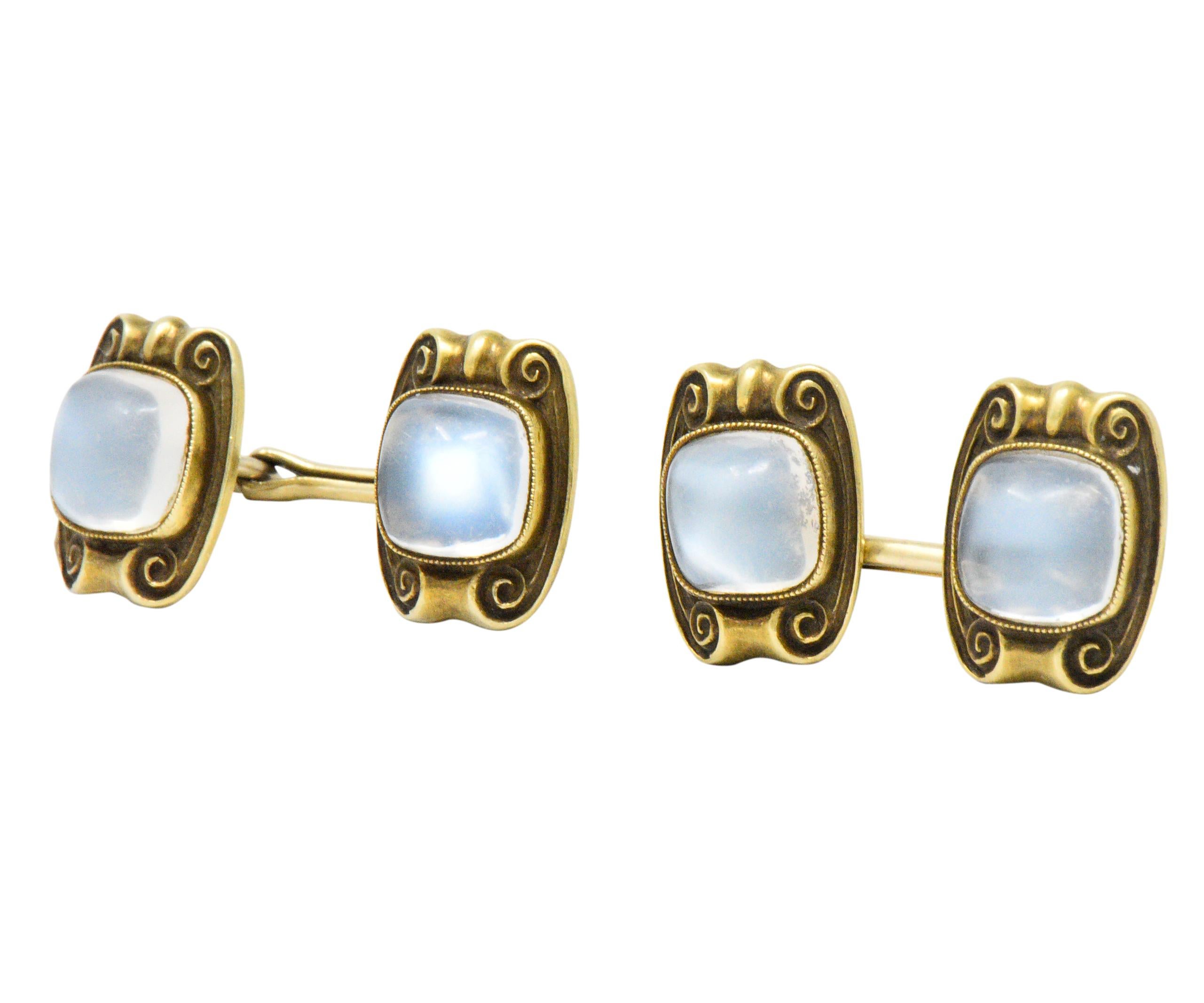 Each centering a square cabochon cut moonstone measuring approximately 8.4 x 8.5 mm

Beautiful billowy silver blue

Bezel set with millegrain and scrolling gold detail

Chain link style cufflink

Measuring: 13.9 x 10.5 mm

Total Weight: 10.8