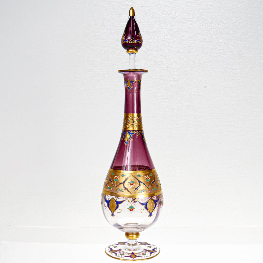 A fine Art Nouveau cordial set.

Attributed to the Moser Glass Company.

With elaborate gilding and enamel decoration. 

Comprising a decanter and stopper with 6 tall cordial wine glasses or stems. Each stem with a small, highly decorated cup, an
