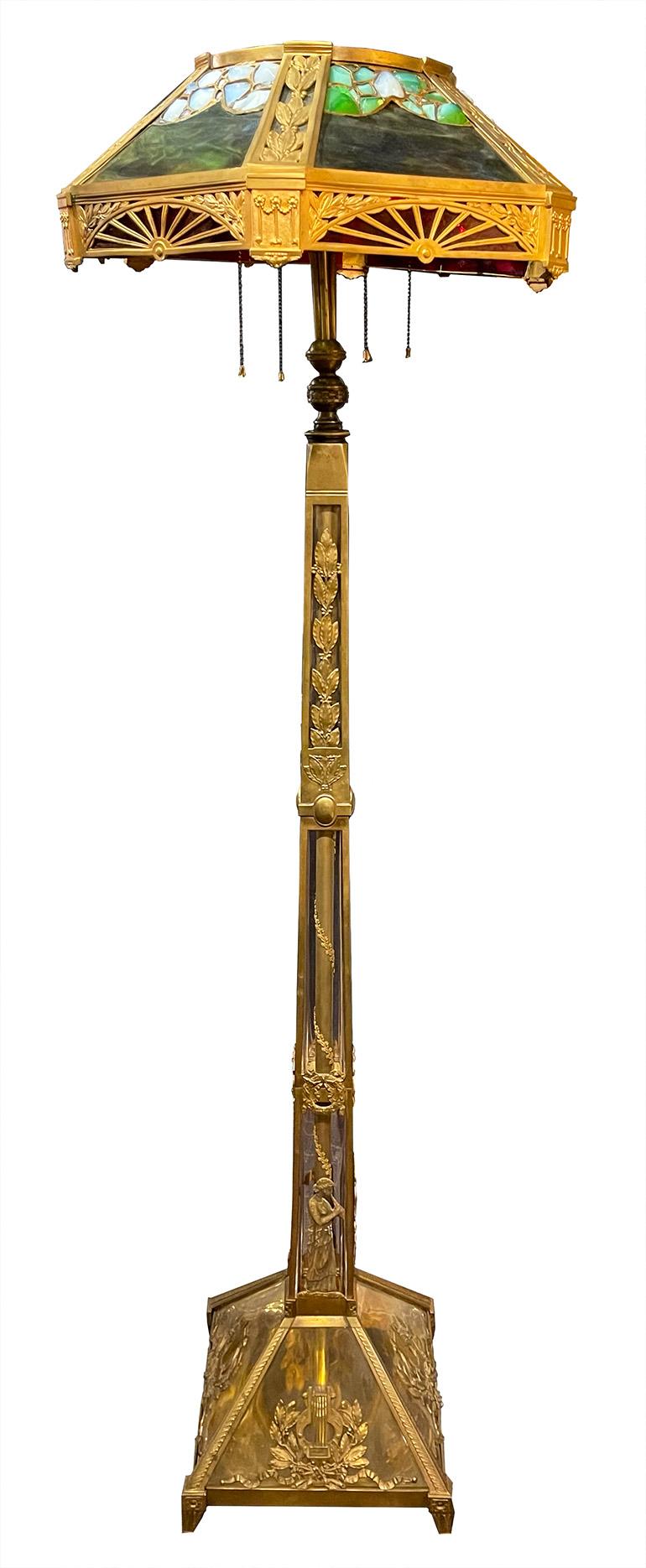An early 20th century Art Nouveau style floor lamp made from brass and multicolored slag glass.

Dimensions: 66