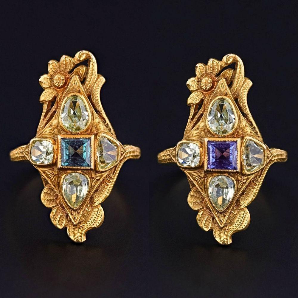 Este anillo antiguo, un luminoso tesoro de la época Art Nouveau (hacia 1910-1920), presenta una fascinante alejandrita de los Urales de 0,59 ct, de color cambiante y certificada por el GIA, rodeada de cuatro crisoberilos de color verde pálido, todo