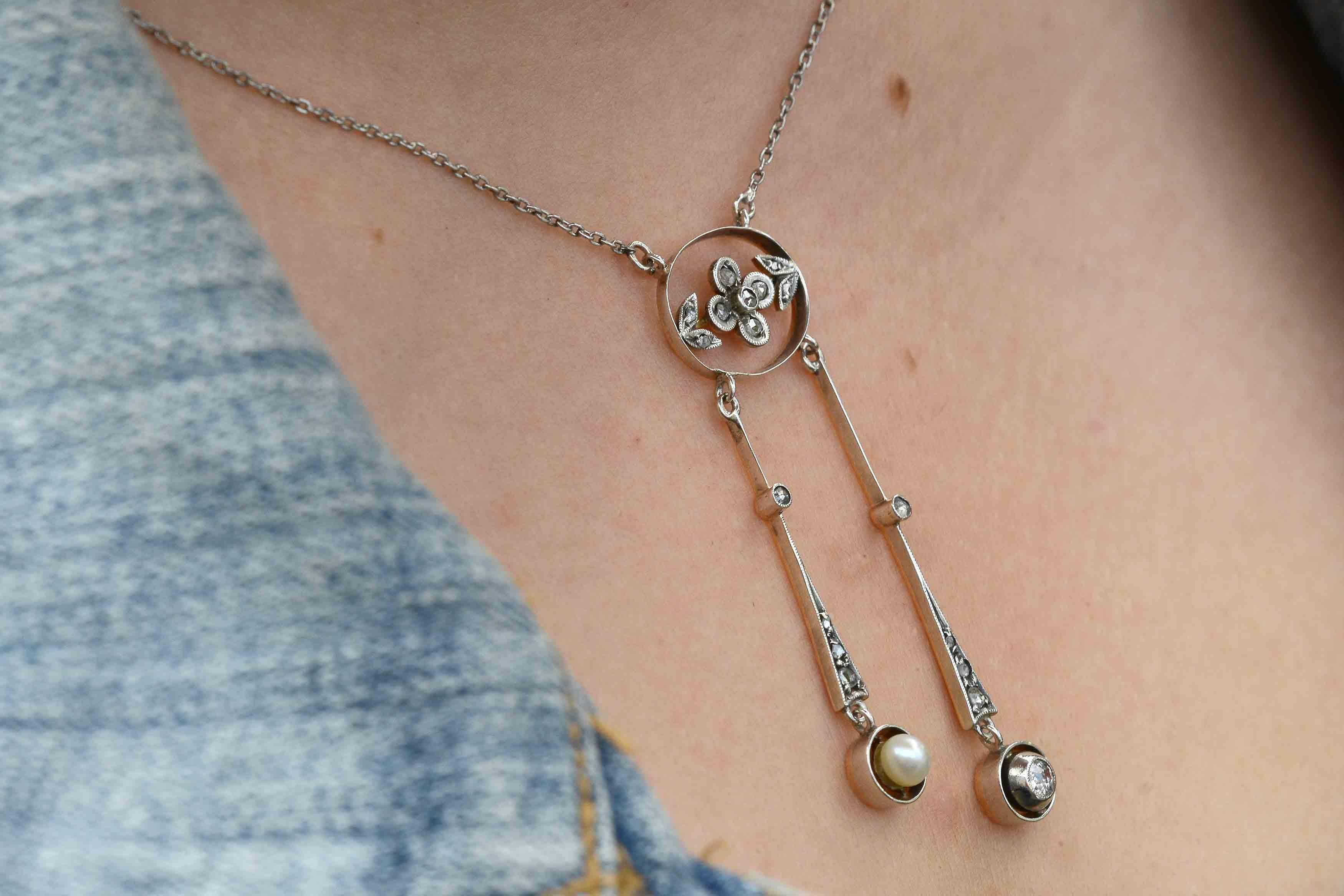 A swoon-worthy, Art Nouveau antique negligée drop necklace loaded with charm. You will love the floral garland center, two tone platinum and gold along with the asymmetrical lavalier of a natural pearl and diamond. 
An amazing wedding day accessory.