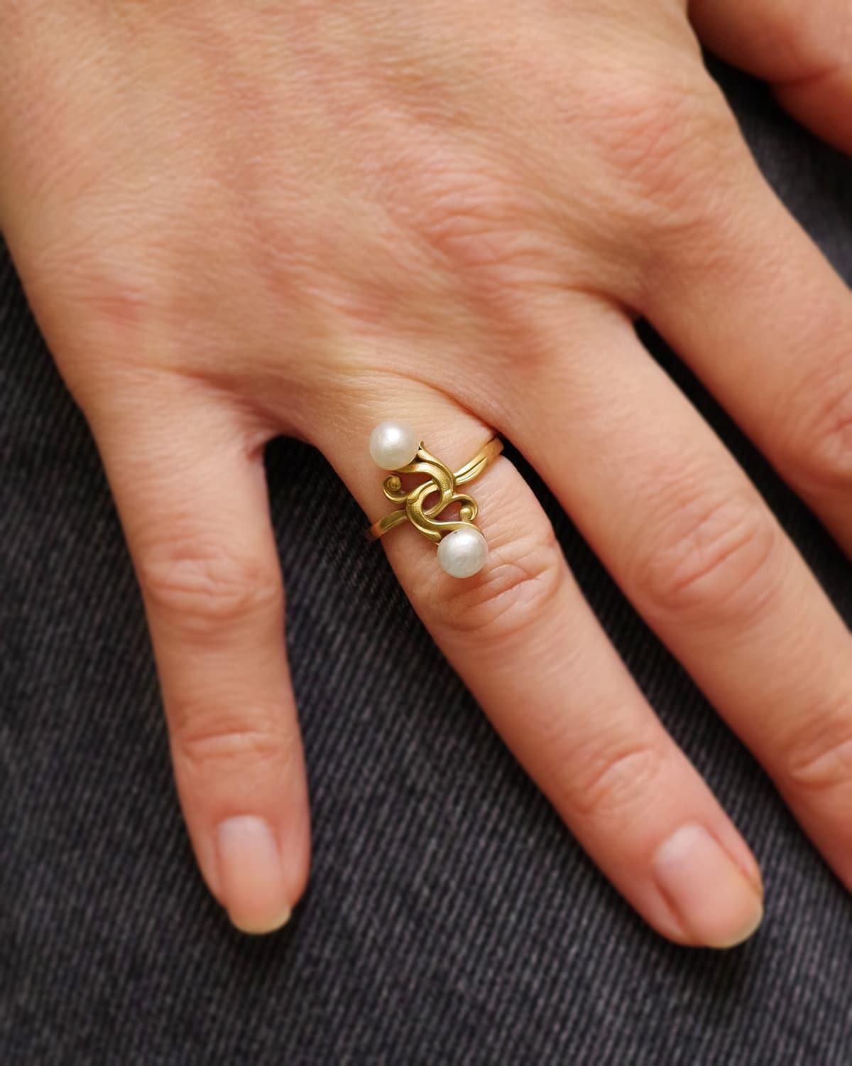 Jugendstil-Perlenring aus 18 Karat Gold. Dieser Ring aus der Zeit um 1900 zeigt ein Mistelblattmotiv, das von zwei zarten Perlen unterbrochen wird, die die weißen Beeren der Mistel darstellen. Antiker Ring, Jugendstil, Frankreich.

Adlerkopfpunze