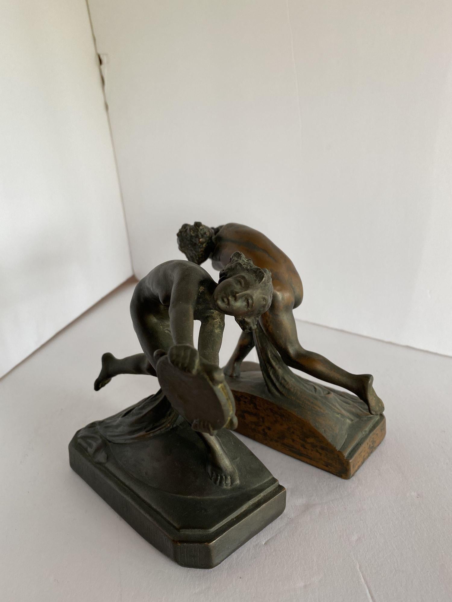 Turn of the century Art Nouveau Nude Female Nymph bronze bookend pair featuring young nymphs each holding a tambourine. 
 
Circa 1900.