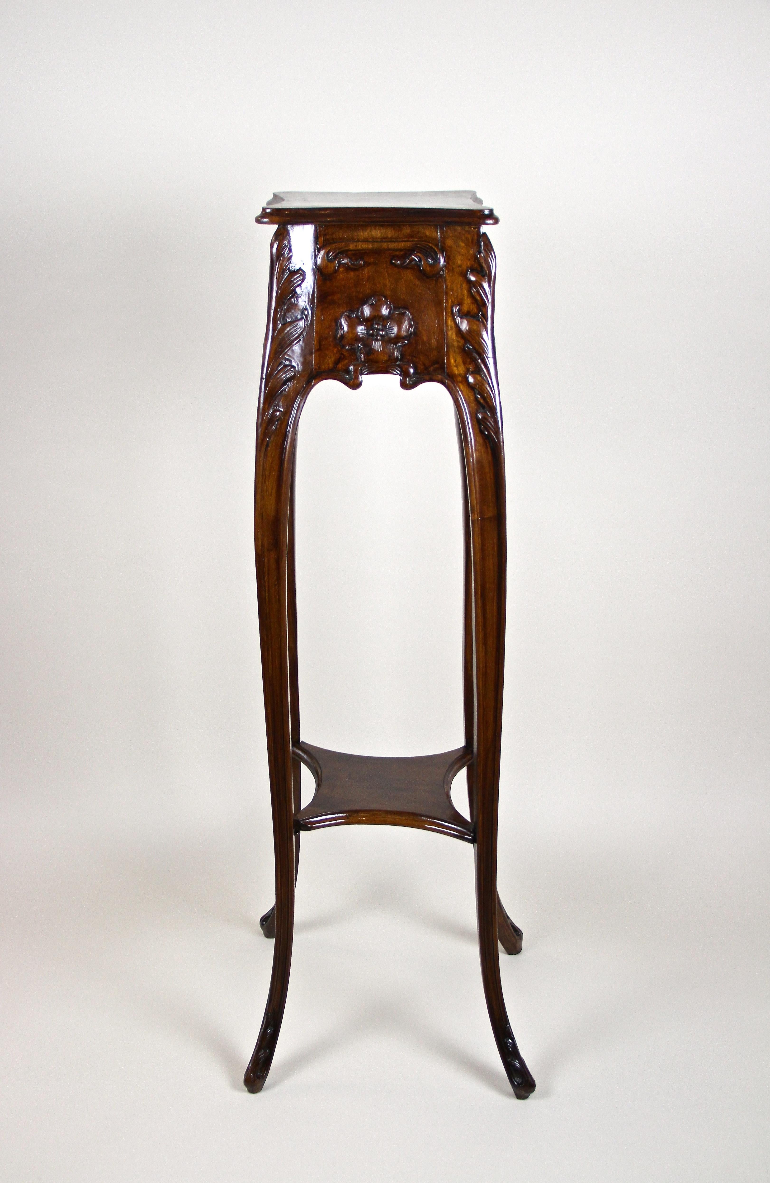 Beautiful Art Nouveau nutwood pedestal from the very early period in Austria around 1900. A unique wooden pedestal with a lovely hand carved floral design and artfully curved lines. Representing typical forms of the Art Nouveau design language, this