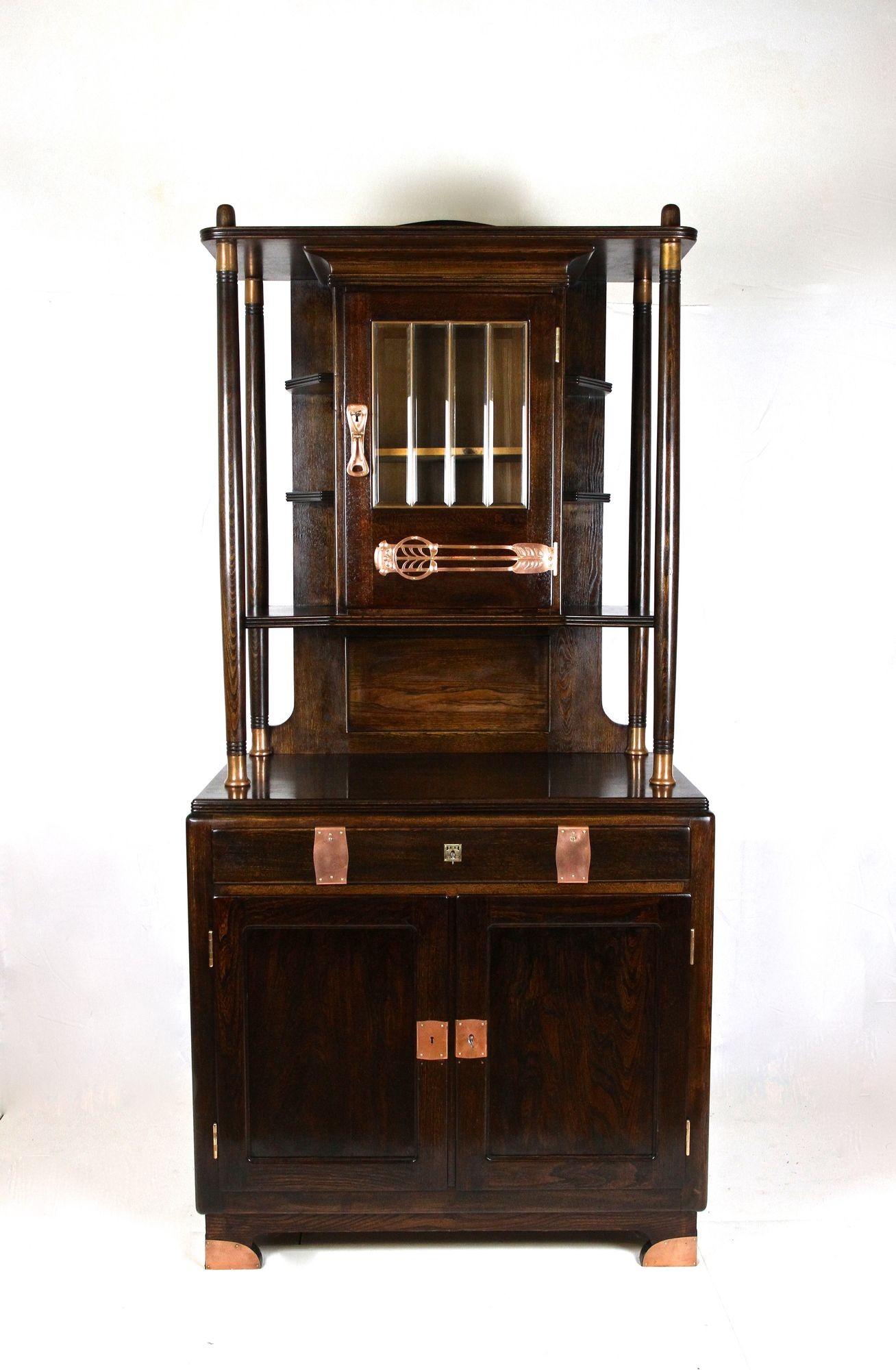 Outstanding Art Nouveau oakwood buffet or cabinet out of Austria from the period around 1910. The lower part provides two wide opening doors with a large storage compartment divided by a shelf and also one lockable drawer. The fantastic designed