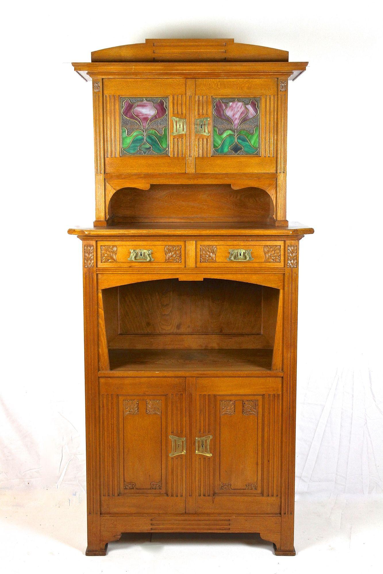 Absolutely charming oakwood Art Nouveau cabinet or buffet originating from period in Austria around 1910. Consisting of two parts, the lower part (reminds a bit of a half cabinet) offers two drawers, a great designed open compartment and two doors.