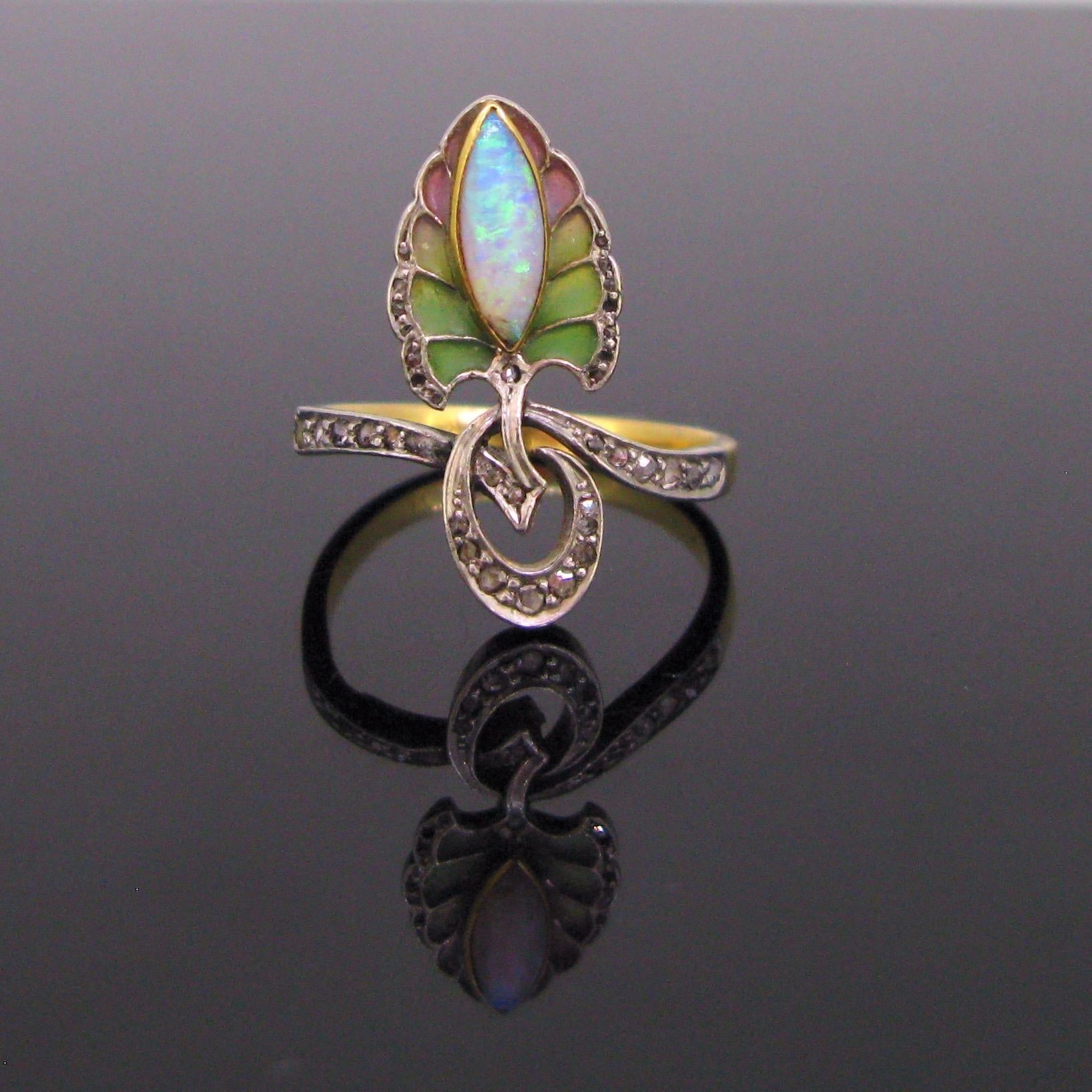 This ring is a real testimony of the Art Nouveau period. It is made in 18kt gold and platinum and it features a leave in enamel made with the technic of the plique a jour. It is adorned with a navette shape opal (tiny cheap on the bottom). This one