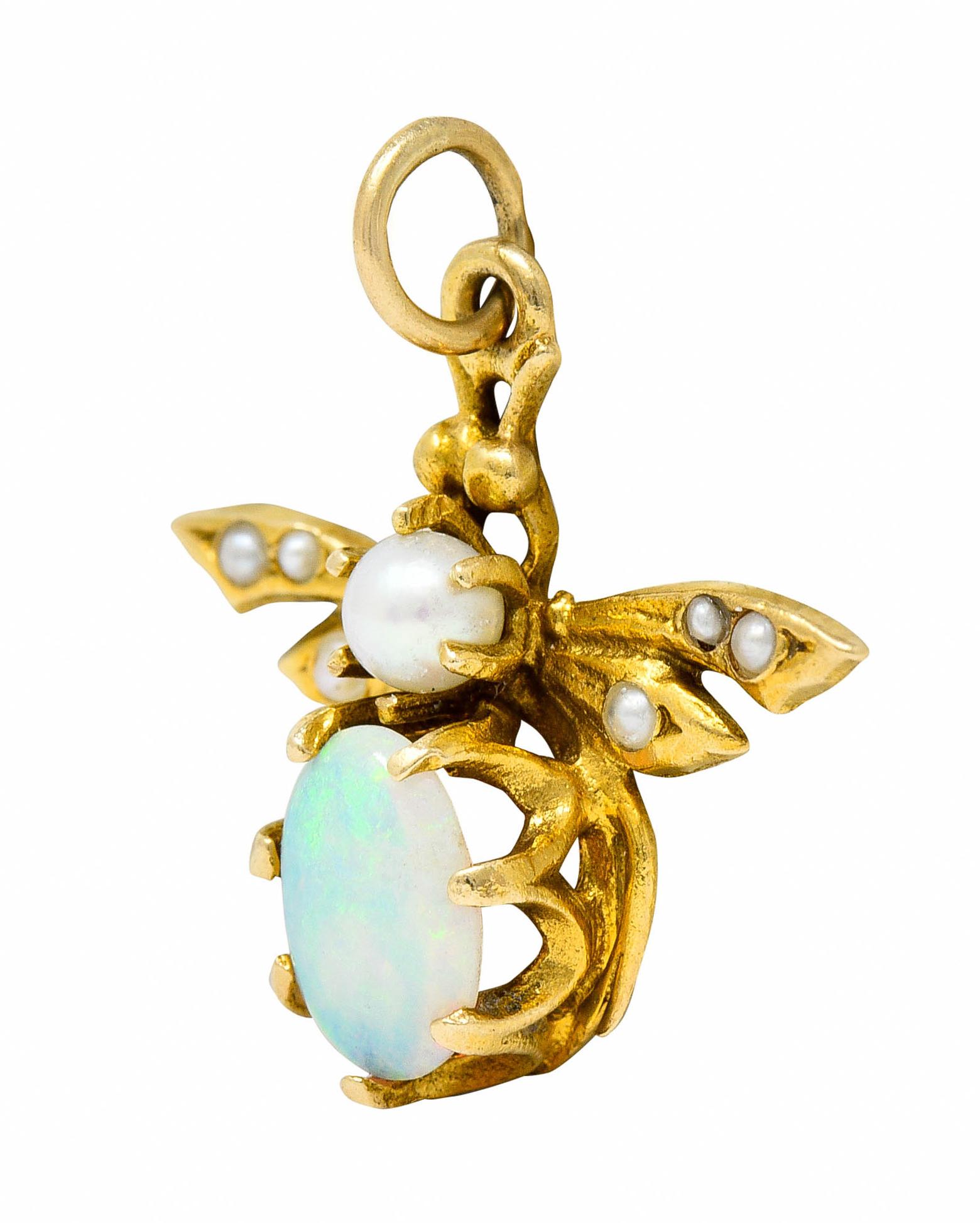 Charm is designed as a stylized winged insect

Featuring a belcher set oval opal cabochon measuring approximately 8.0 x 5.0 mm

Translucent with strong yellow to green play-of-color

Body is set with a 3.0 mm round pearl - white in body color with