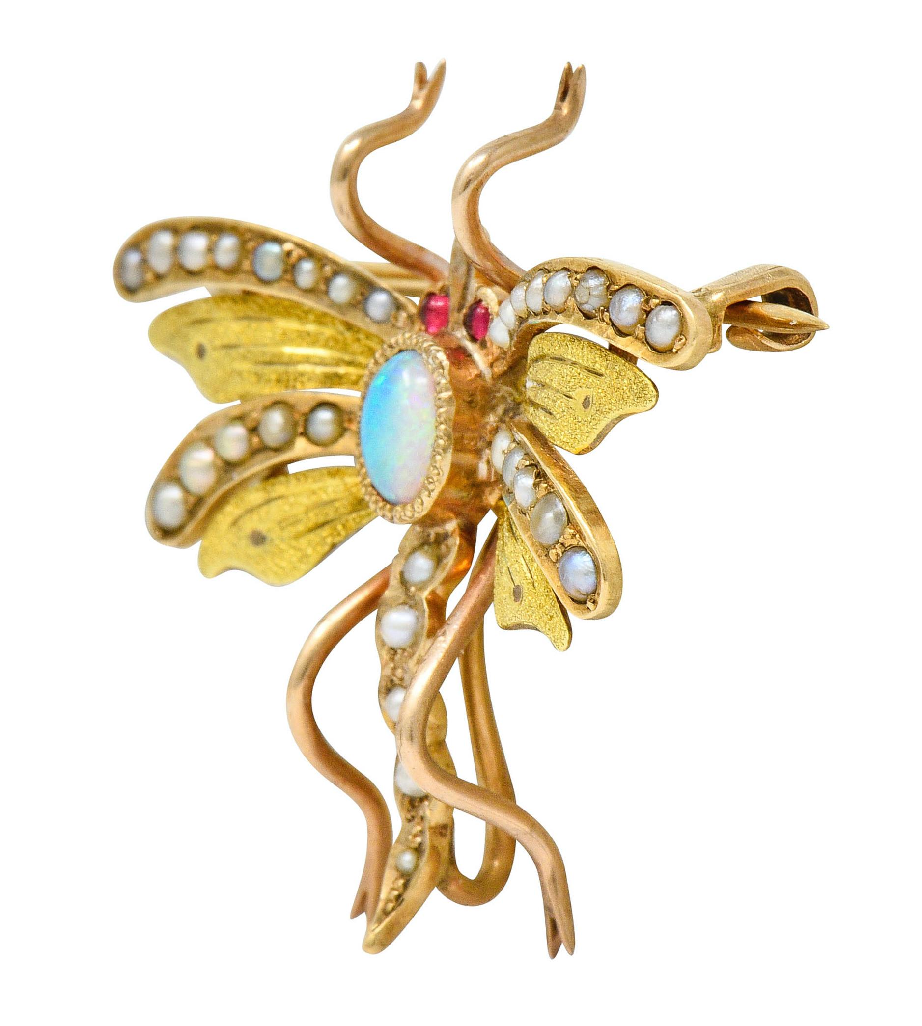 Pendant brooch designed as a stylized flying insect with fanciful wings that feature matte green gold detail

Thorax centers a bezel set opal cabochon measuring approximately 5.0 x 3.5 mm; white body color with strong green/blue