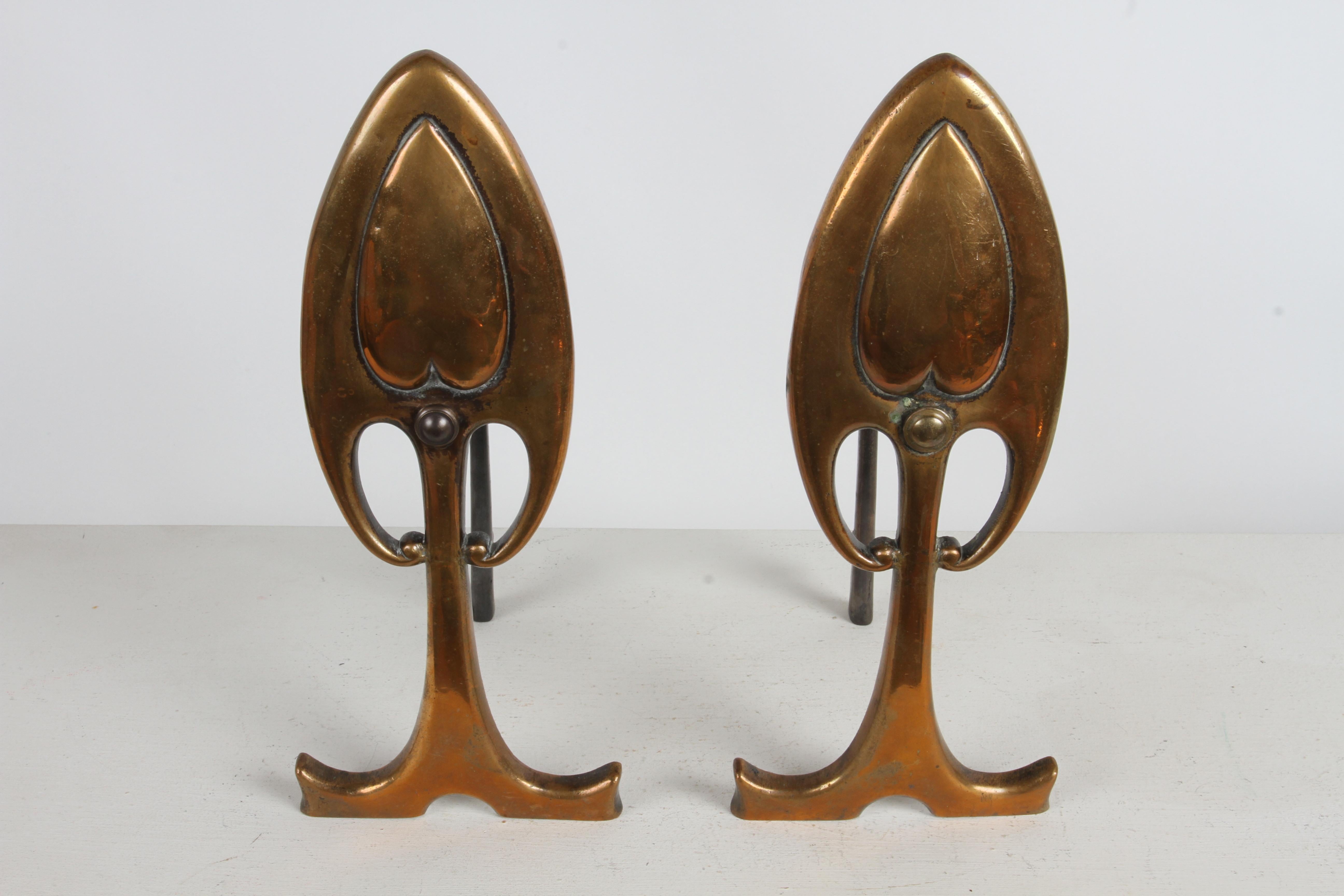Classic petite pair of Art Nouveau or Aesthetic Movement period bronze andirons or firedogs done in repoussee. I believe these to be bronze, they have a slight copper tone to them with heart motif or Anthurium leaf shape. Most likely purchased by