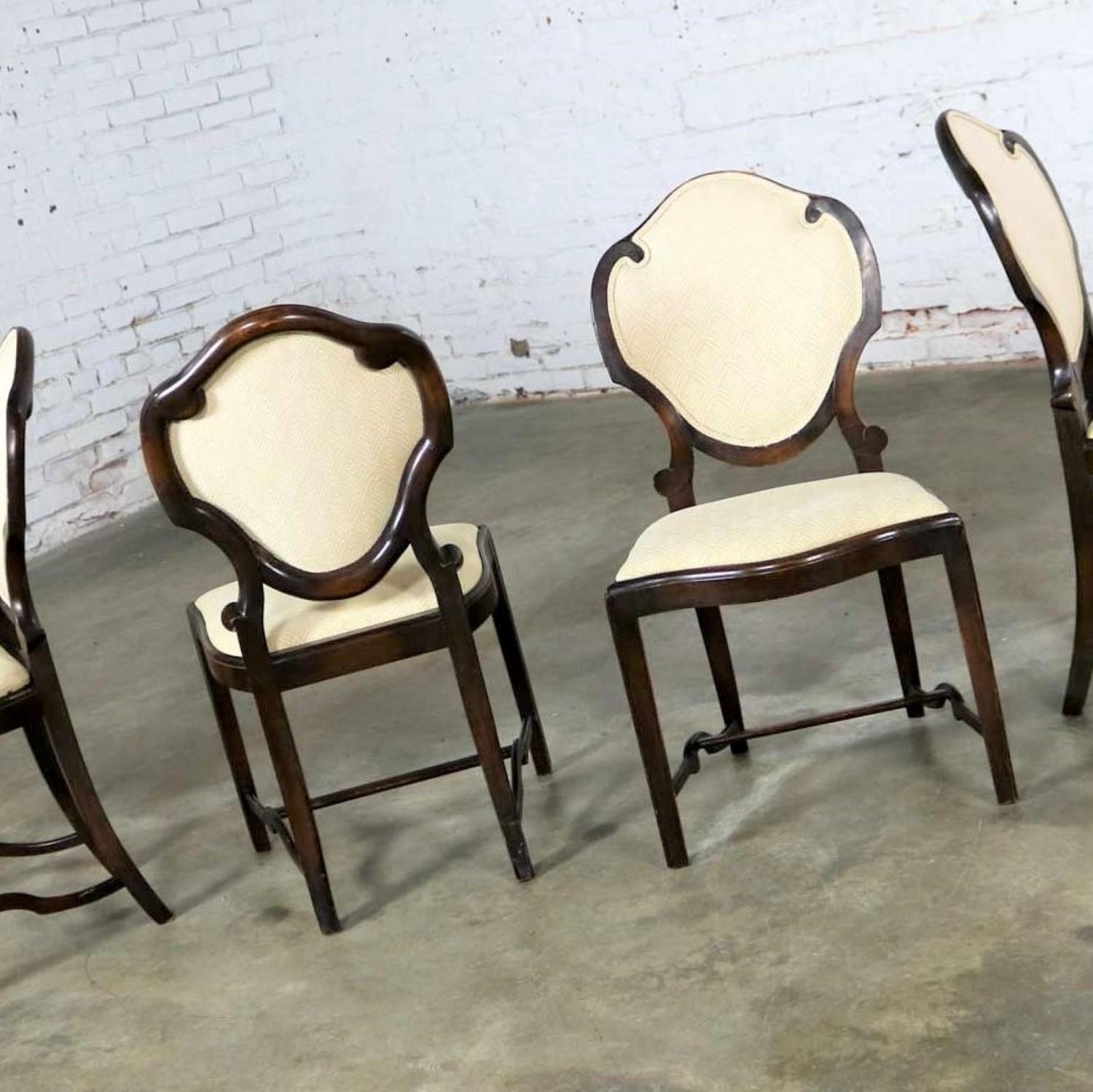 Incredible Art Nouveau or Art Deco set of four dining chairs with shield shaped backs and lots of detail. They are in wonderful original antique condition. They are very solid. The wood frames have lots of beautiful age patina including nicks and
