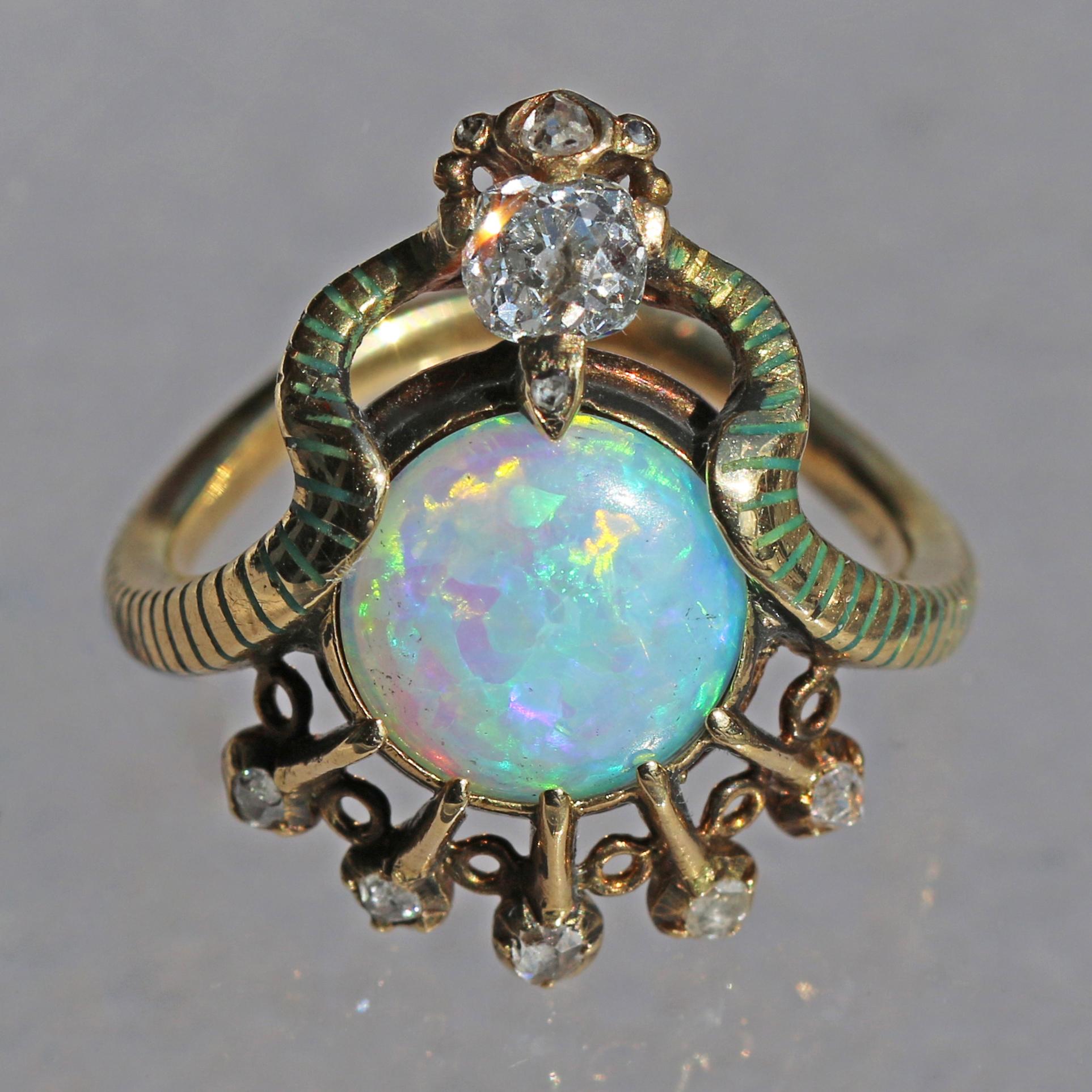 This unique and exceptional ring is astonishing in its concept. The sinuously entwined snake with its green champlevé enamel stripes has an affinity with ancient Egyptian rings, as does the fine cabochon opal to the solar disc Aten. A fabulous