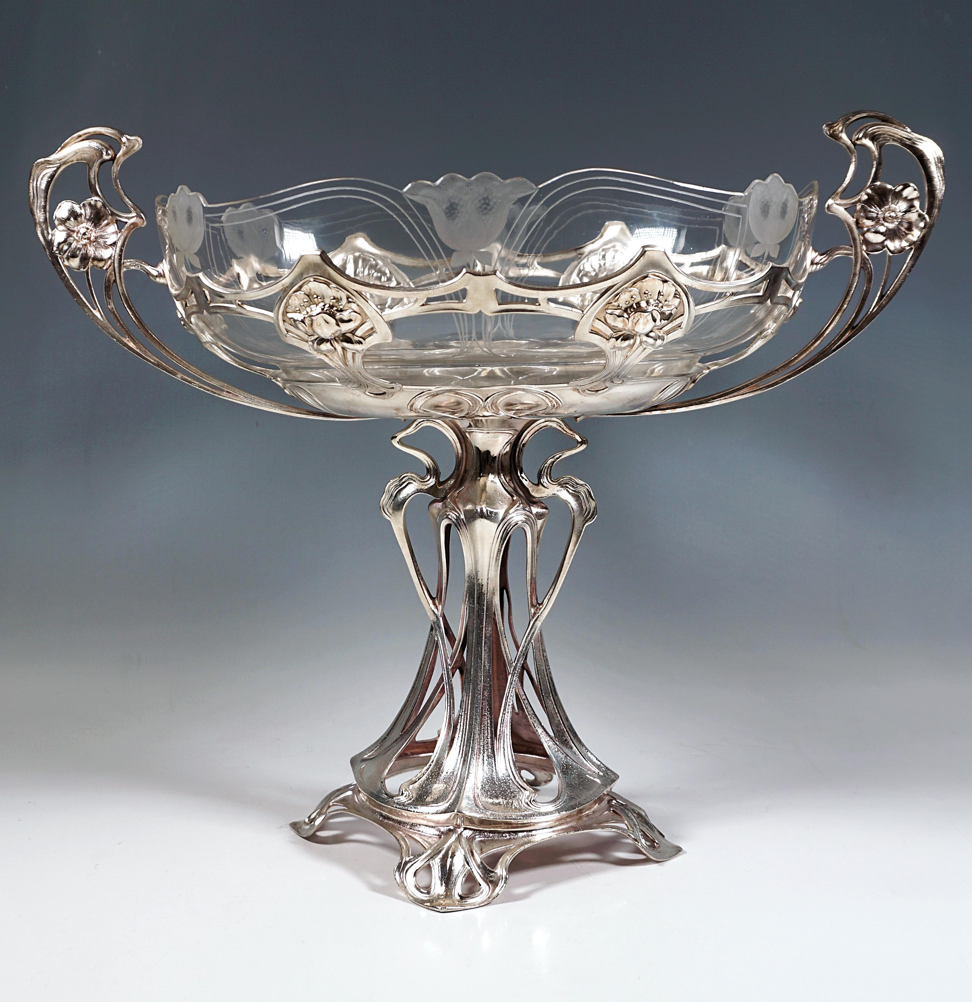 Lavishly designed silver-plated frame, standing on four feet that form a square in the shape of artfully entwined stylised branches and tendrils, supporting the large oval openwork with interwoven relief-like flower medallions, with tendrils