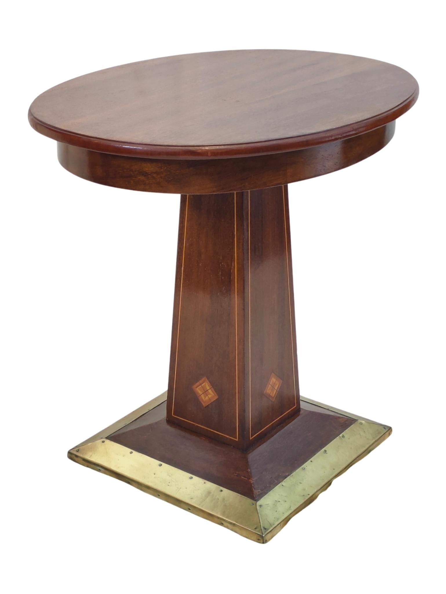 Cette élégante table de salon Eleg est fabriquée à partir d'un riche acajou et dégage une sophistication intemporelle. Son plateau rond et élégant est soutenu par un piédestal magnifiquement effilé, orné d'incrustations de bois complexes. La base