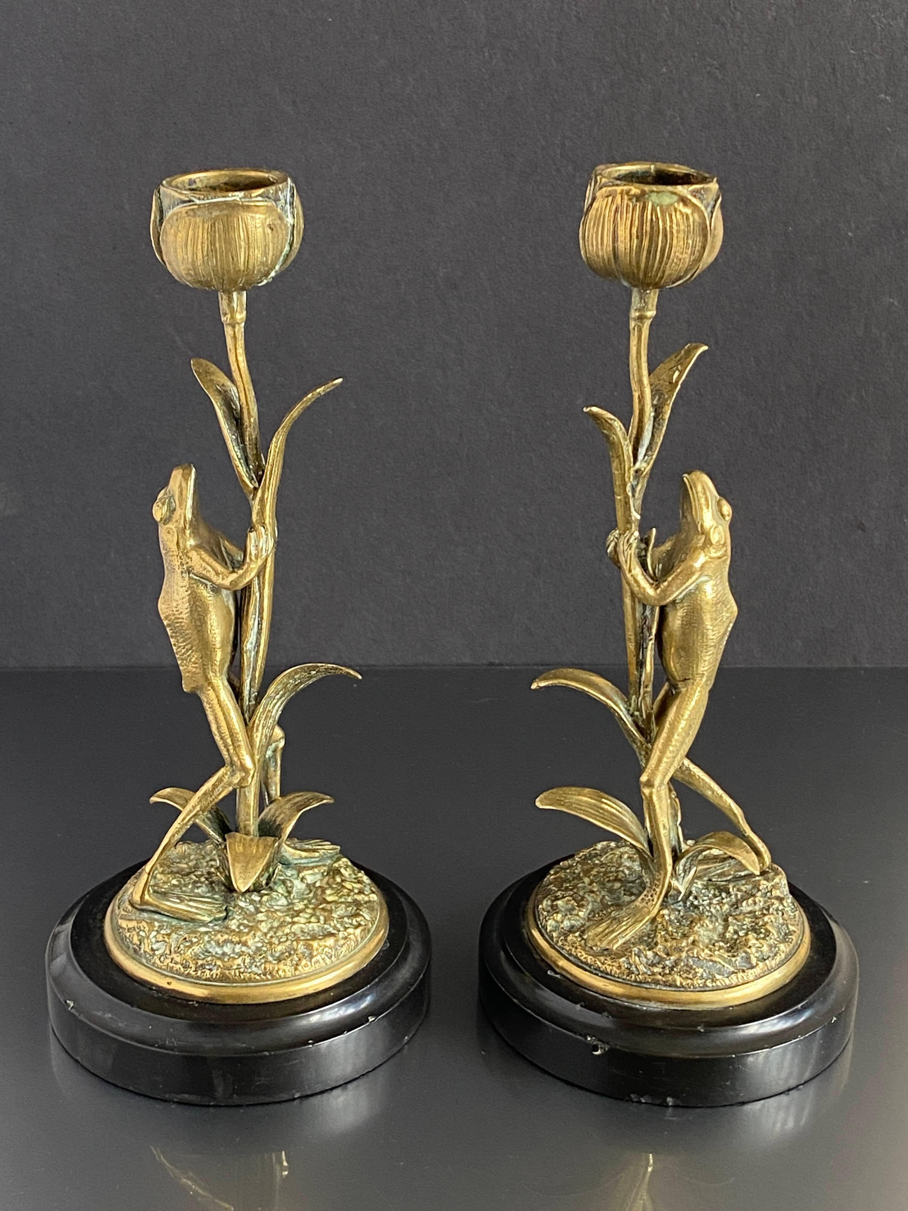 Ein ungewöhnliches Paar Jugendstil-Kerzenhalter, modelliert als Frösche, die auf Lotusblumen klettern, auf einem schwarzen, runden Marmorsockel. In gutem Zustand mit altersgemäßen Gebrauchsspuren, um 1890, Herkunft unbekannt.
