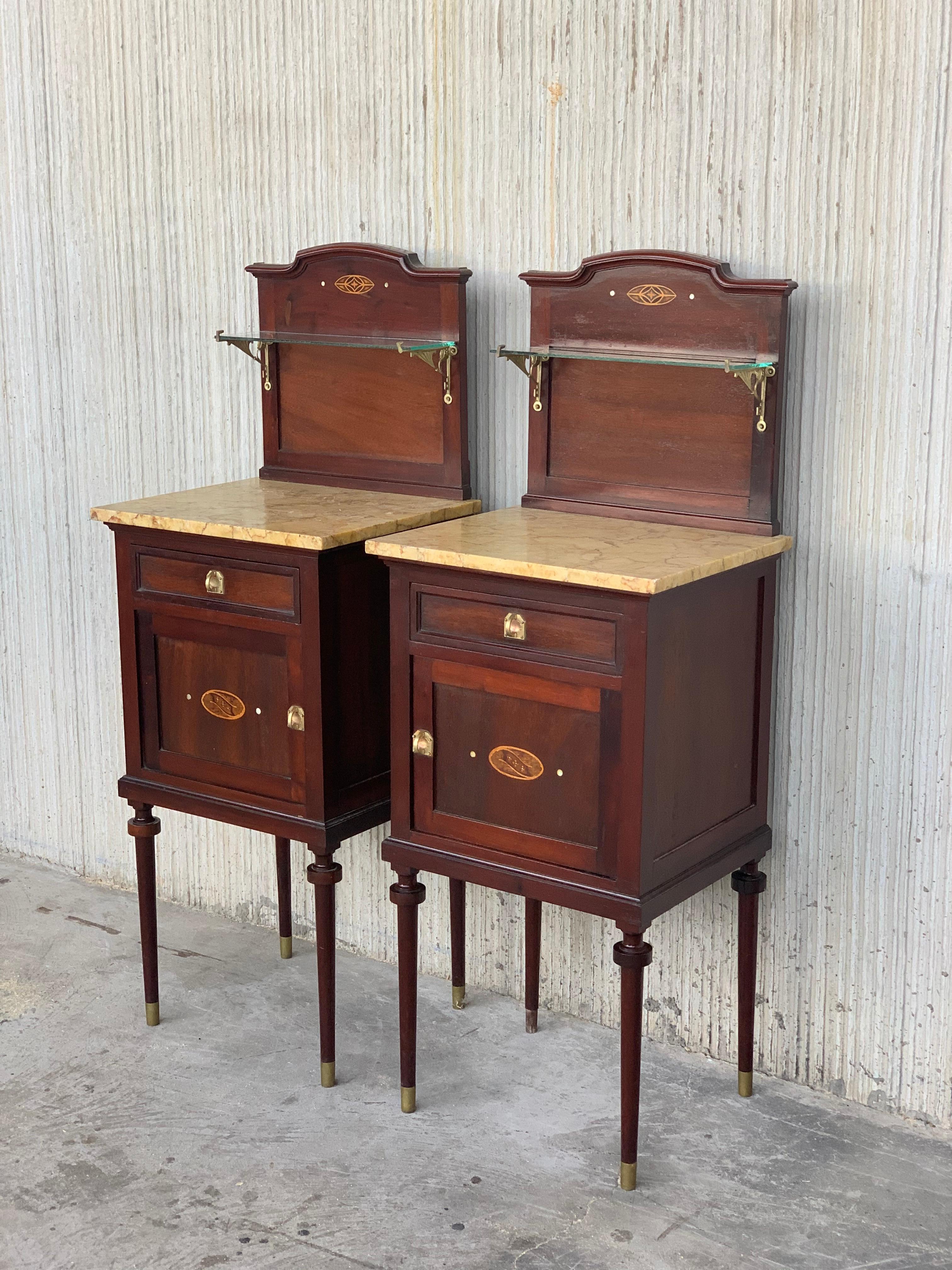 Late 19th century Art Nouveau pair of nightstands in walnut, bronze handles, restored and waxed.
The doors and crest have a marquetry details and a mother pearls circles in both sides 
The inside compartment it´s covered of porcelain.
The needle