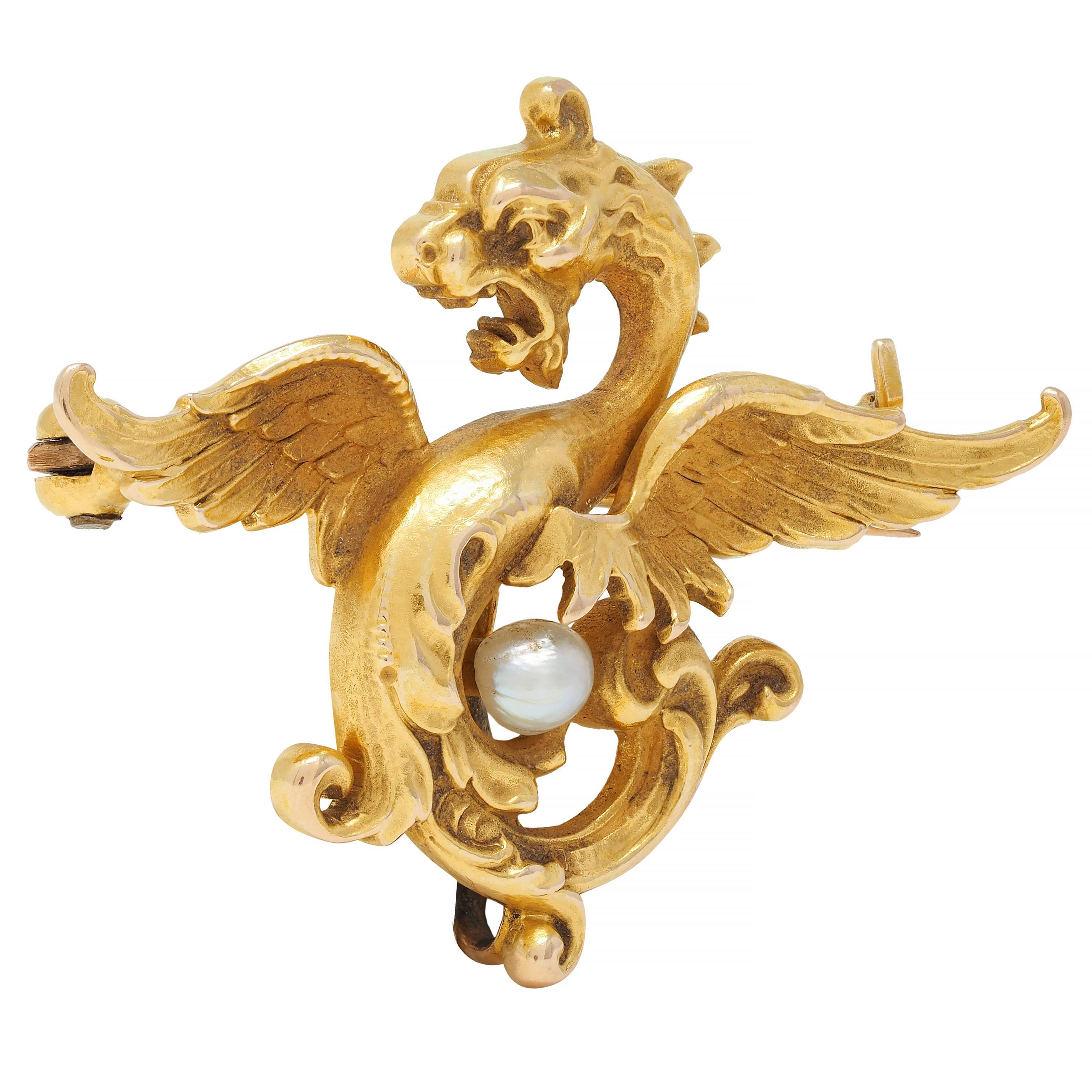 Designed as a stylized dragon creature with fierce expression, spread wings, and furling tail
Dimensional with engraved and grooved textured detailing 
Tail curls around a near-round baroque pearl 
Gray body color with moderate iridescence