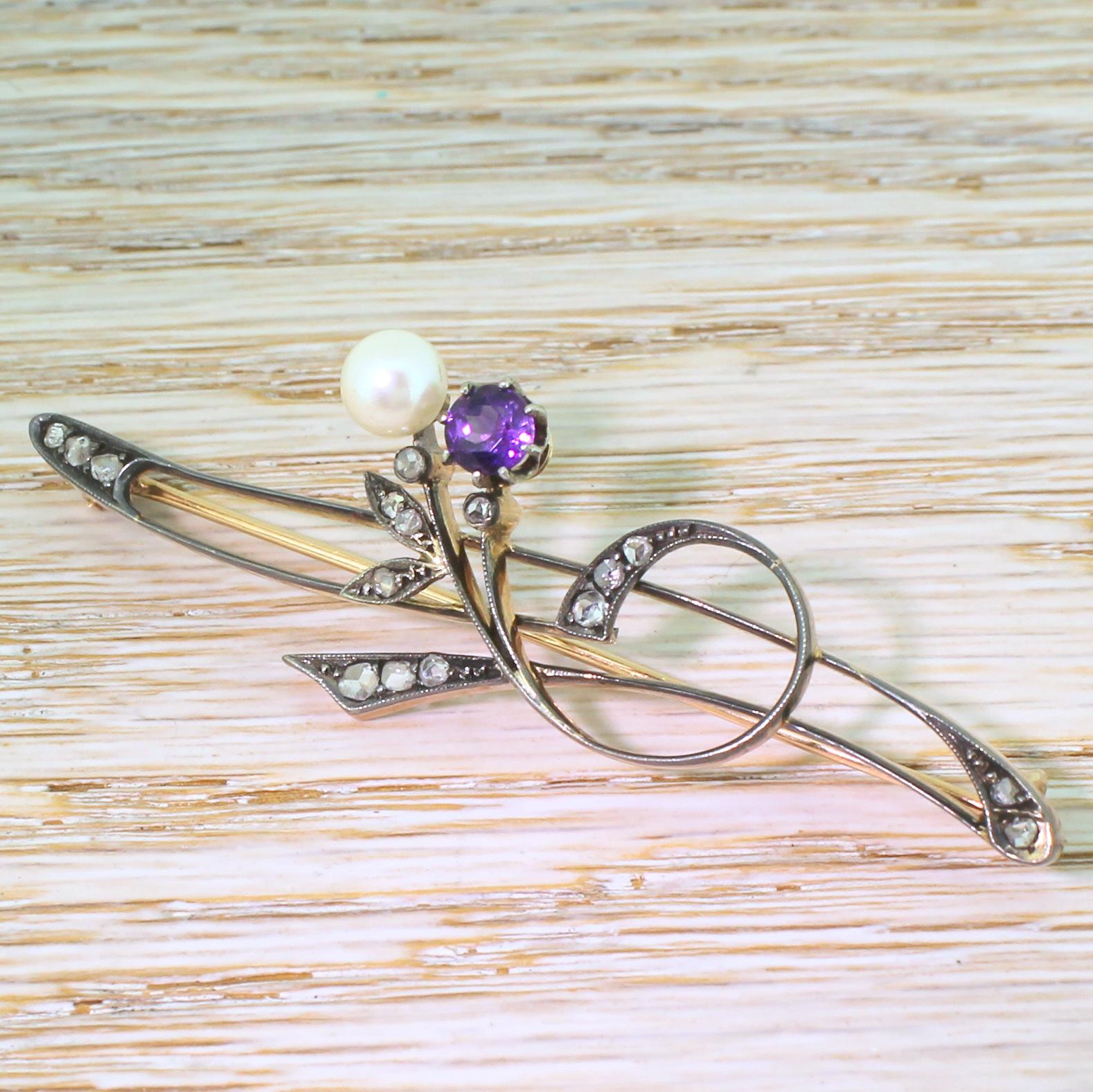 An almost unbearably pretty Art Nouveau brooch. The asymmetrical floral motif features two buds: one a rich, regal purple amethyst; the other a white, lustrous pearl. Crafted in silver – which has oxidised to a striking dark grey – backed in yellow