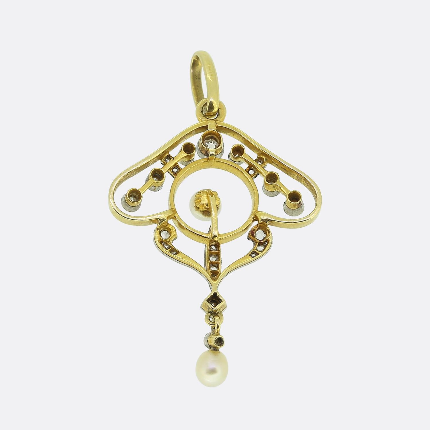 Qui abbiamo uno squisito ciondolo a goccia tratto dal movimento Art Nouveau. Questo pezzo antico è stato realizzato in oro giallo 18 ct e presenta un delicato motivo traforato. Il ciondolo è ornato da una perla bianca centrale, elegantemente